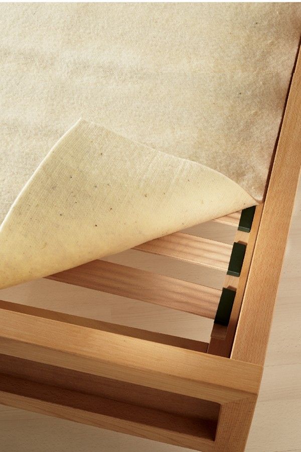 Finkhof Matratzenschoner in naturweiß aus bio Wolle (kbT) mit 200x200cm liegt auf einem Rost, Ecke umgeklappt