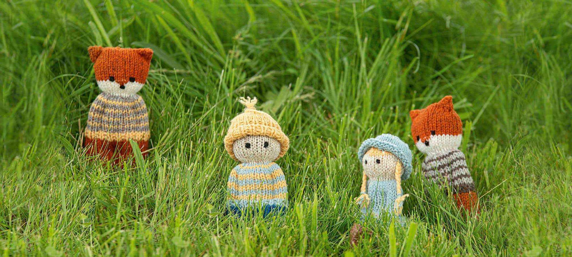Kleine Strickpüppchen in Wiese als Beispiel für Buch ,,Stricklieblinge"