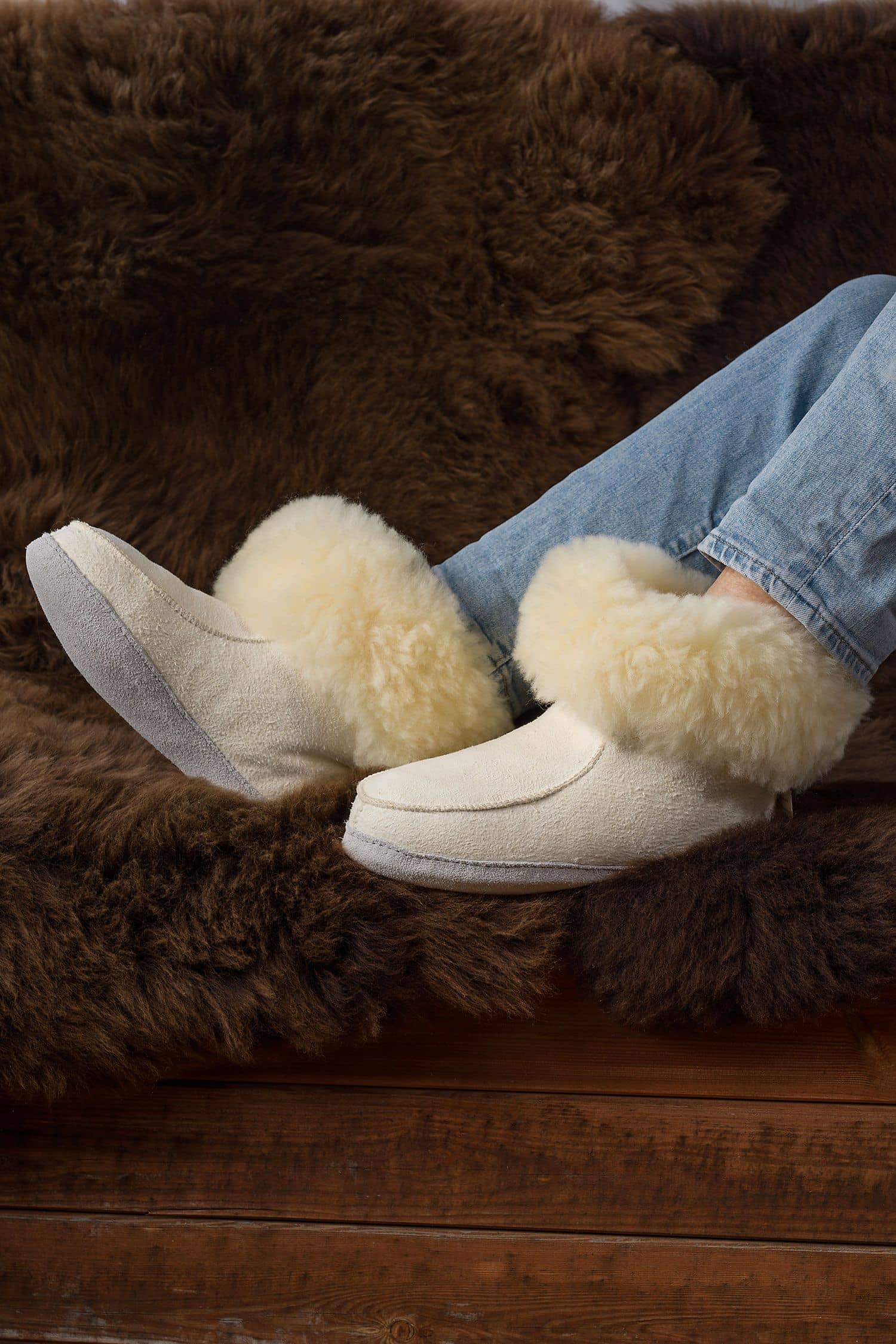 Person trägt relugan gegerbte Fellschuhe aus Schaffell und Rindsleder vom Finbkhof, darunter ein braunes Fell