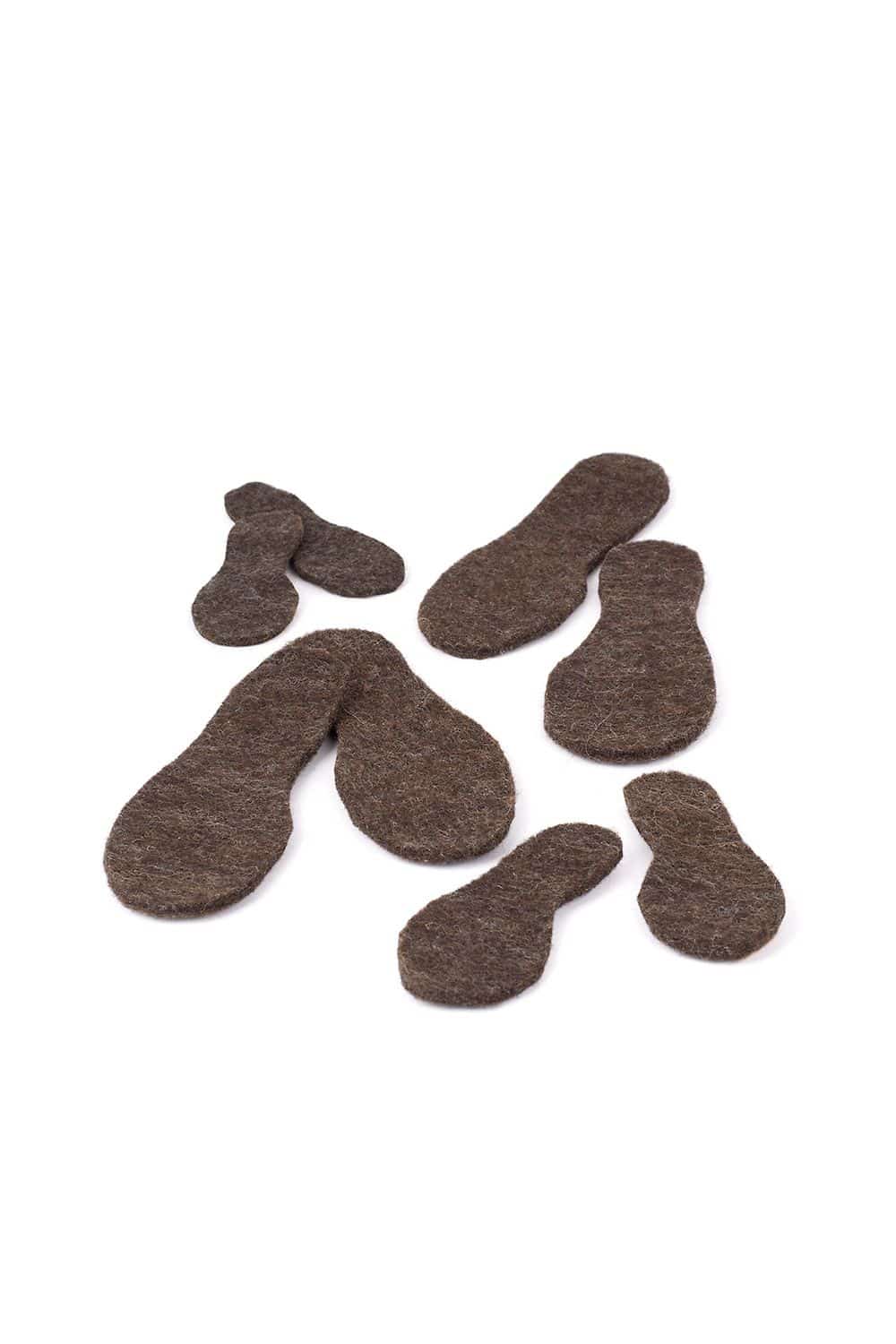 Filzsohlen (kbT) Filzsohlen in verschiedenen Größen aus bio Wolle (kbT) vom Finkhof liegen auf weißem Untergrund verteilt