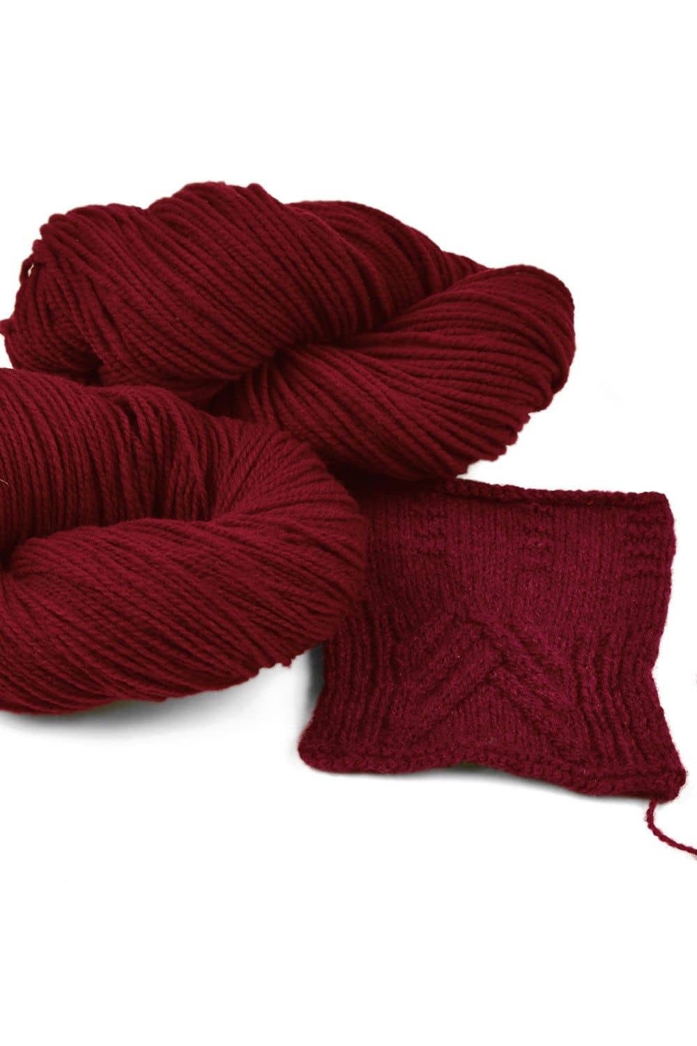 Finkhof Merinowolle dünn gefärbt bordeaux bordeauxrote dünne Finkhof Merinowolle aus bio Wolle (kbT) mit Strickstück davor, weißer Untergrund