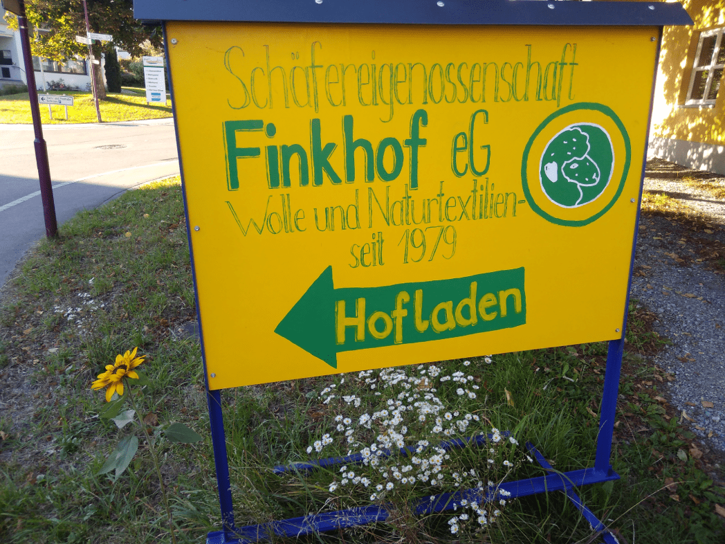 gelbes Schild, dass auf Finkhof Hofladen zeigt