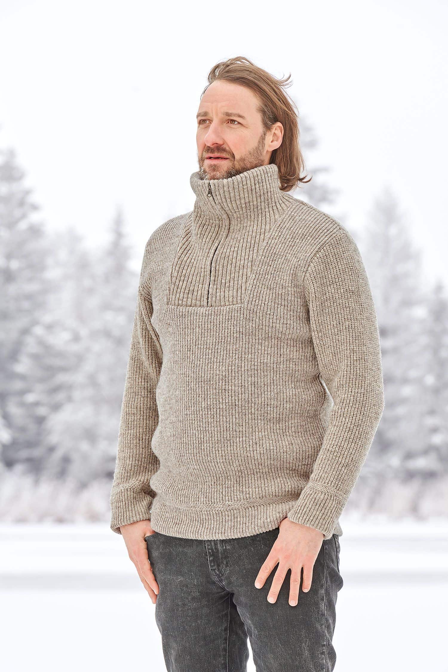 Mann trägt grauen Finkhof Troyer aus bio Wolle (kbT) vom Merinolandschaf in winterlicher Landschaft