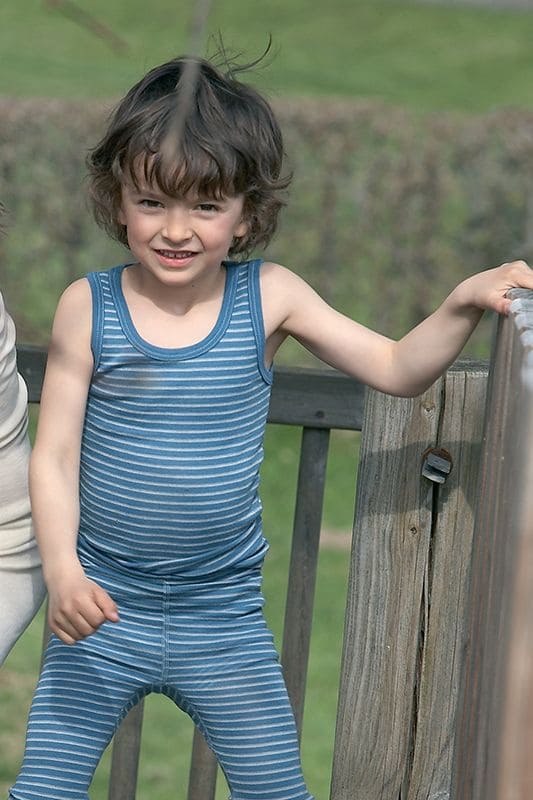 Geringeltes Wollträgerhemd blau/naturweiß blau weiß gestreiftes Unterhemd aus bio Wolle (kbT) mit passender Hose von Junge aus Klettergerüst getragen