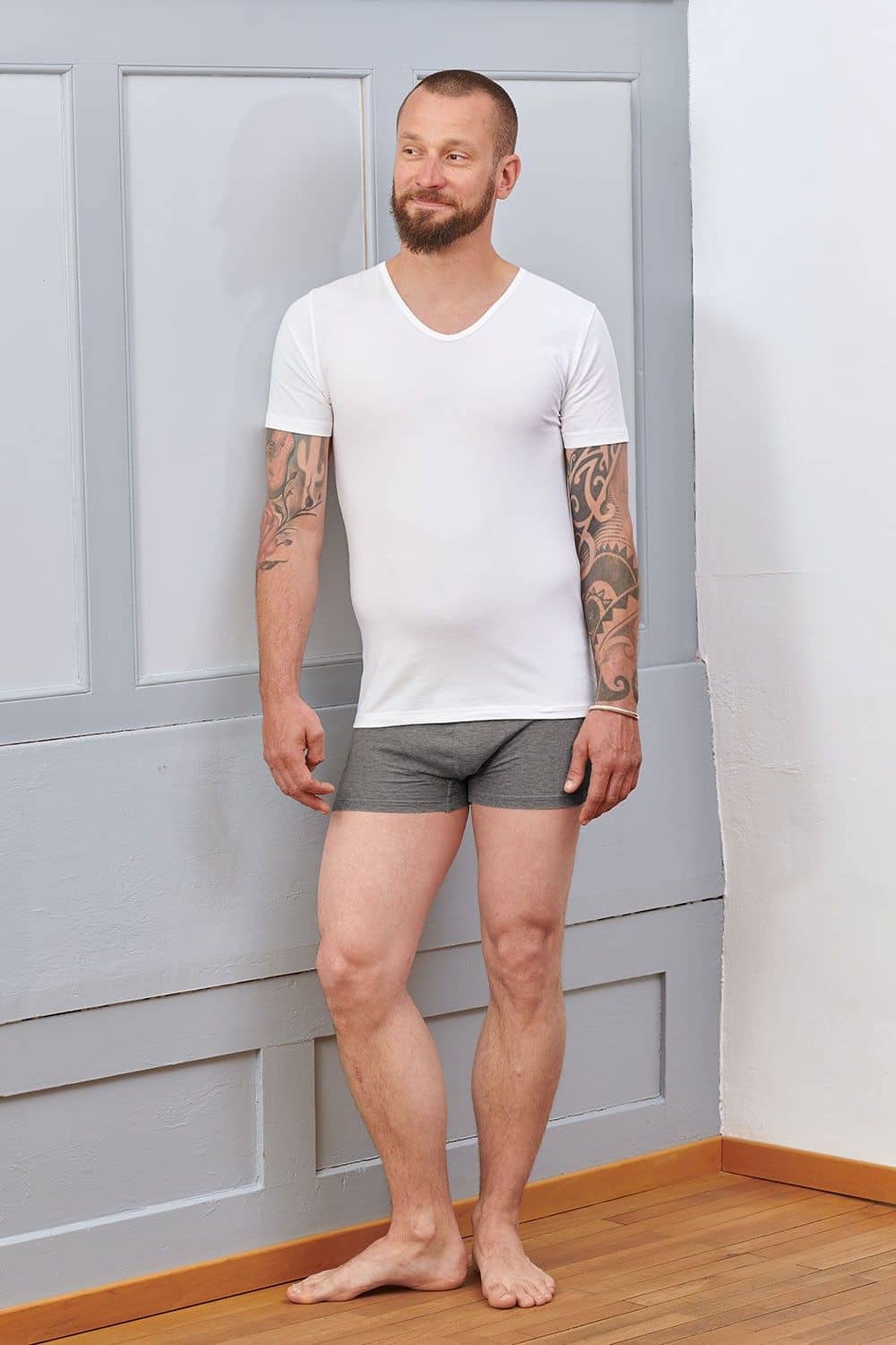 Mann trägt Boxershorts und ein schwarzes Kurzarmshirt aus bio Baumwolle (kbA) und Elasthan mit V Ausschnitt