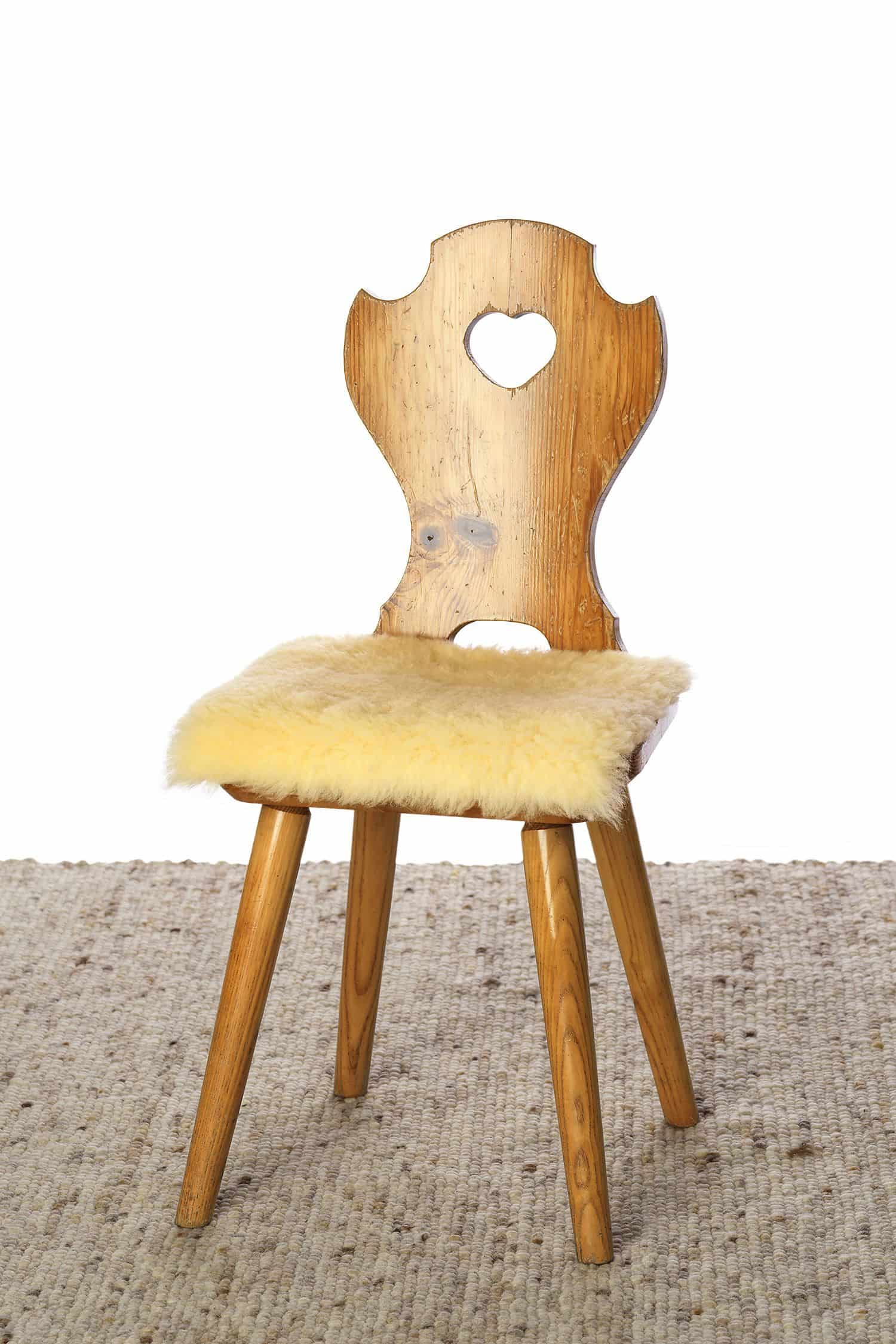 quadratische Stuhlauflage aus gelblichem relugan gegerbtem Schaffell vom Finkhof auf Holzstuhl
