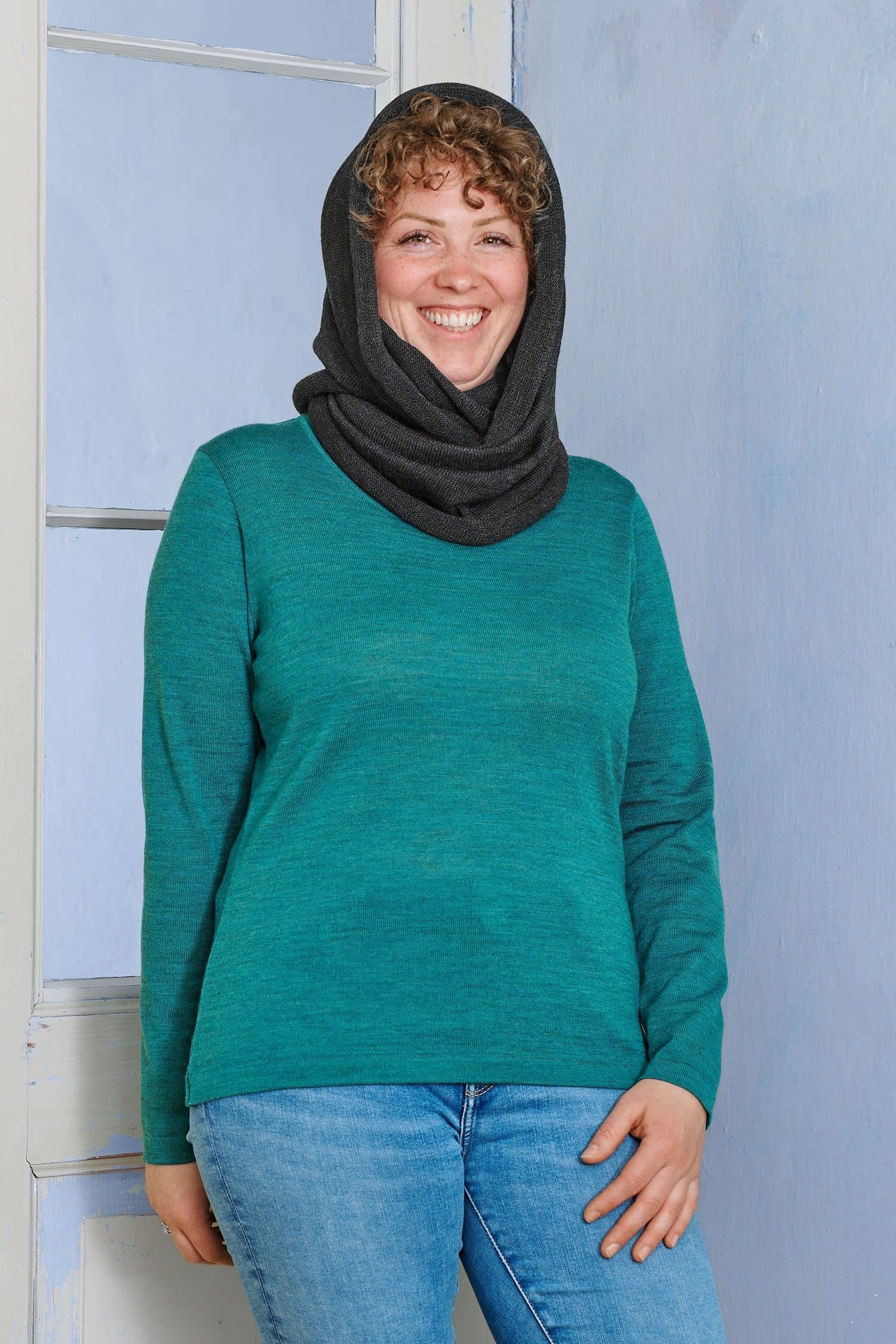 Frau trägt türkises Shirt und dunkelgrauen Schlauchschal aus bio Wolle (kbT) vom Finkhof als Kapuze