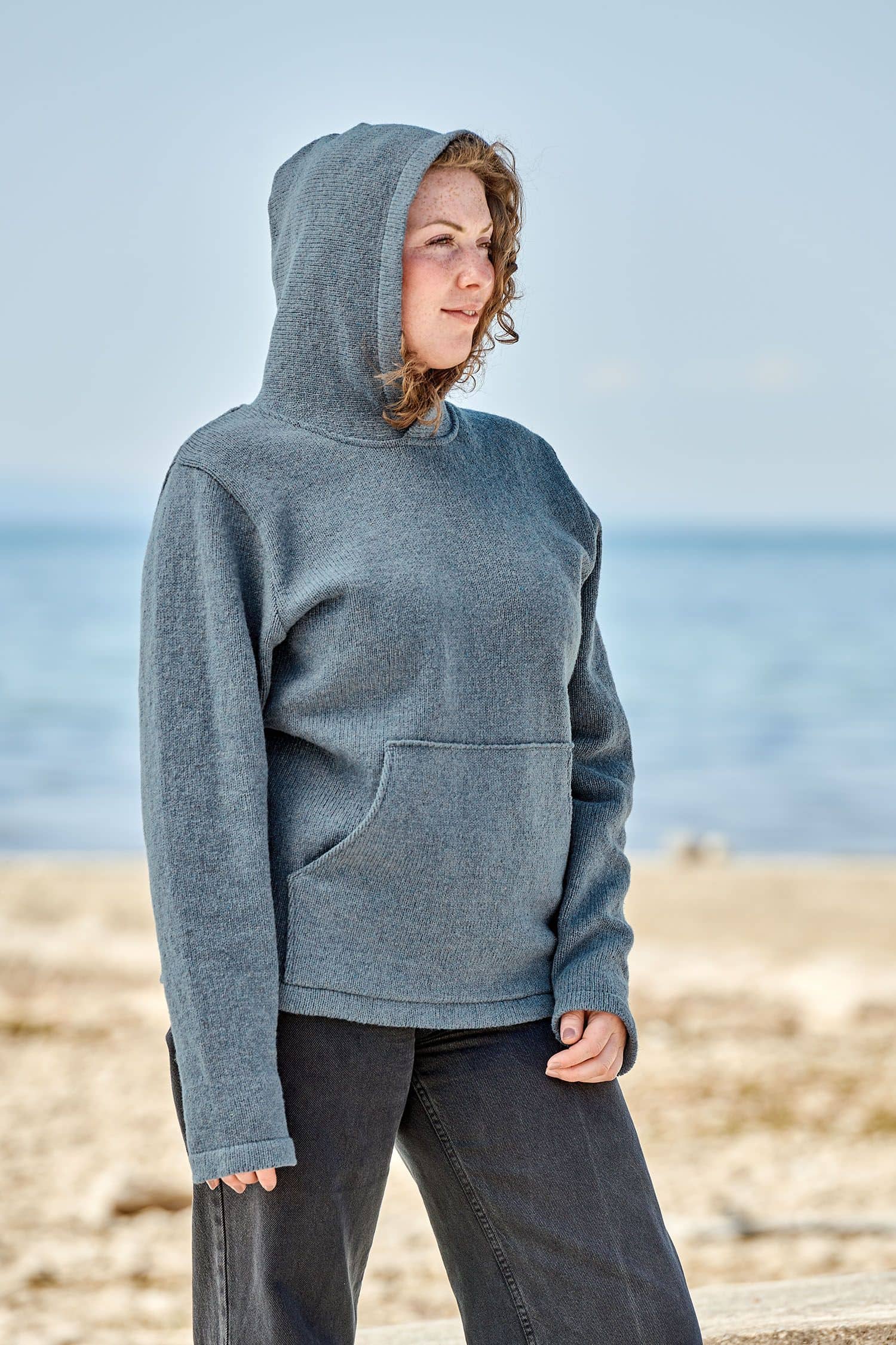 Frau trägt rauchblauen Kapuzenpullover aus bio Merinowolle (kbT) vom Finkhof