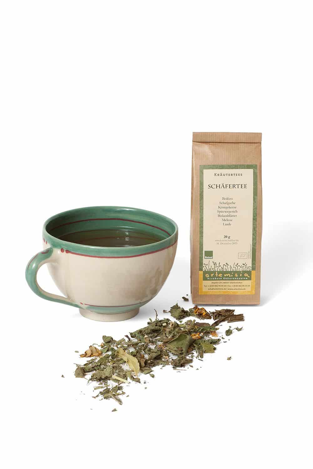 Schäfertee in 20g Verpackung mit verschiedenen getrockneten Kräutern und Teetasse auf weißem Untergrund