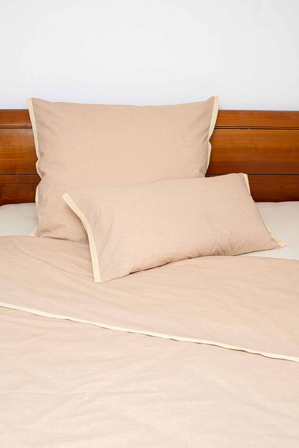ungefärbte Bettwäsche aus bio Baumwolle (kbA) in dunkelbraunem Holzbett