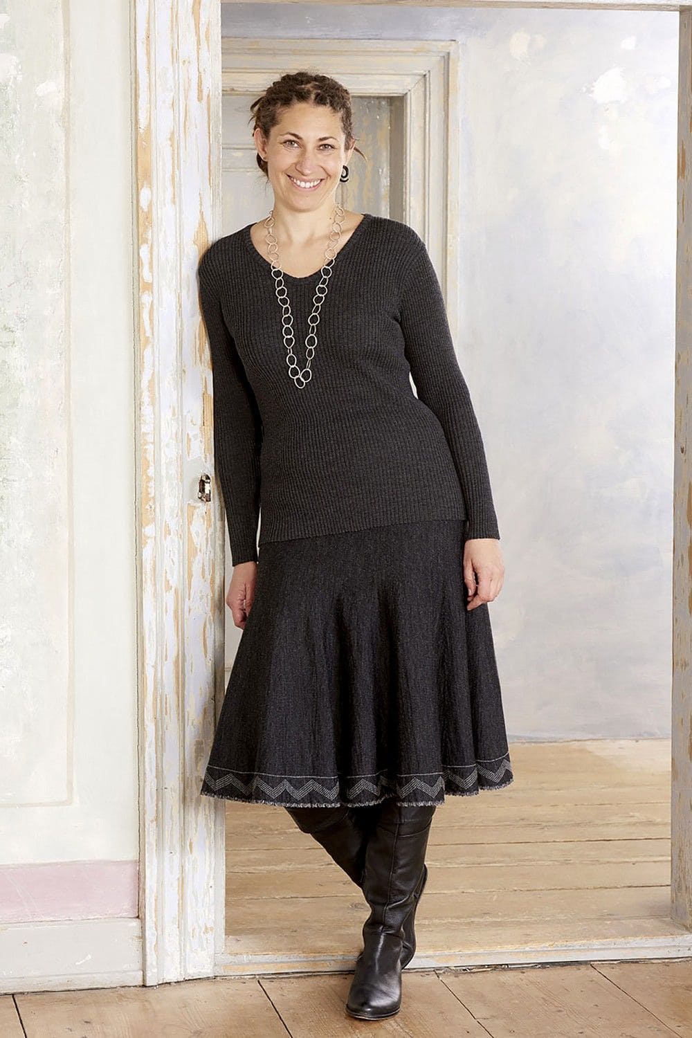 Frau mit schwarzem Rock und Stiefel trägt anthrazitgraues Rippshirt mit V Ausschnitt aus bio Wolle (kbT) vom Finkhof