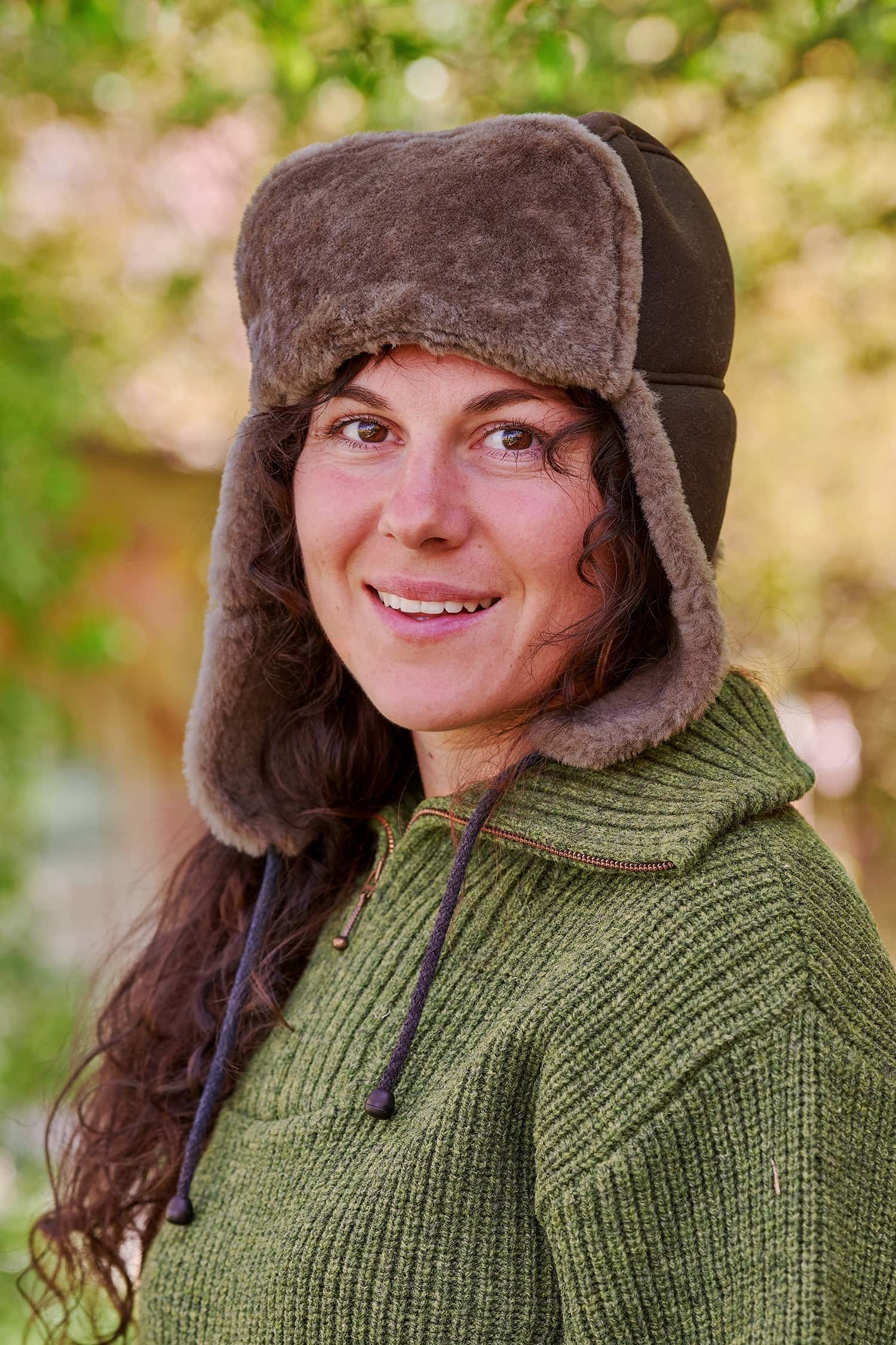 Frau trägt eine braune Fellmütze vom Finkhof und einen grünen Pullover