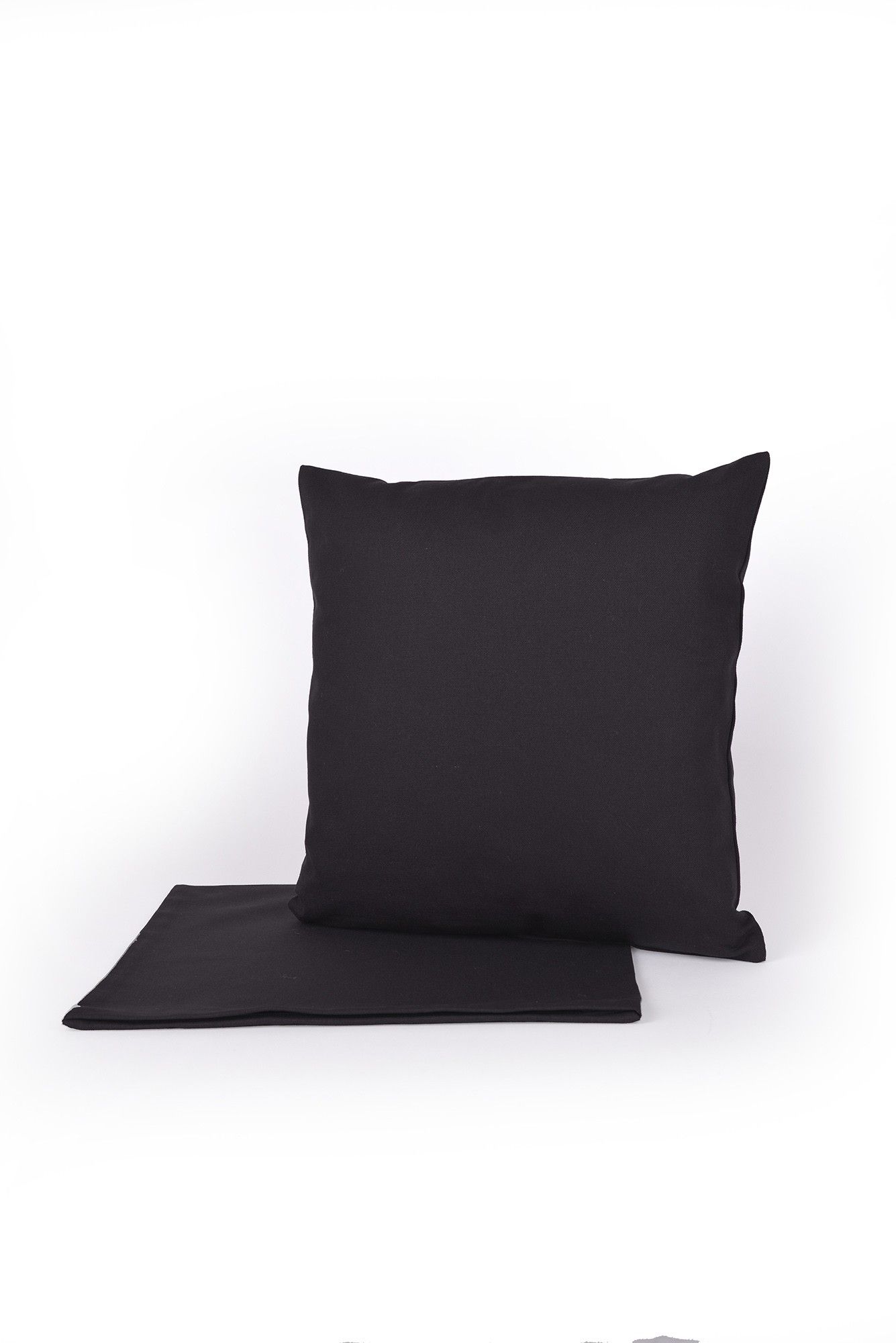 anthrazitgrauer Sofakissenbezug aus bio Baumwolle (kbA) vom Finkhof mit Kissen drinnen und leerem Kissen