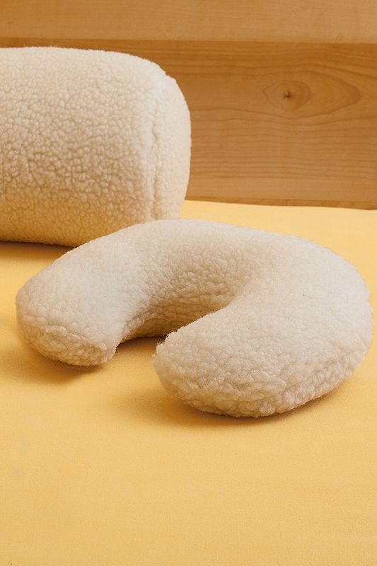 Nackenhörnchen mit Wollplüschbezug naturweiß naturweißes Nackenhörnchen vom Finkhof mit Wollplüschbezug aus bio Wolle (kbT) auf orangem Laken