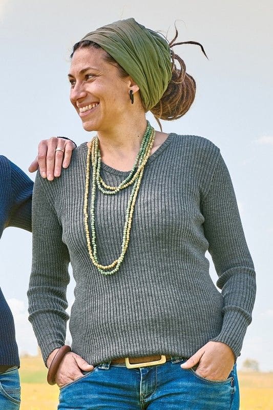 Frau trägt graues Shirt mit Rippstoff aus bio Wolle (kbT) vom Finkhof, grüne lange Kette und ein grünes Haarband