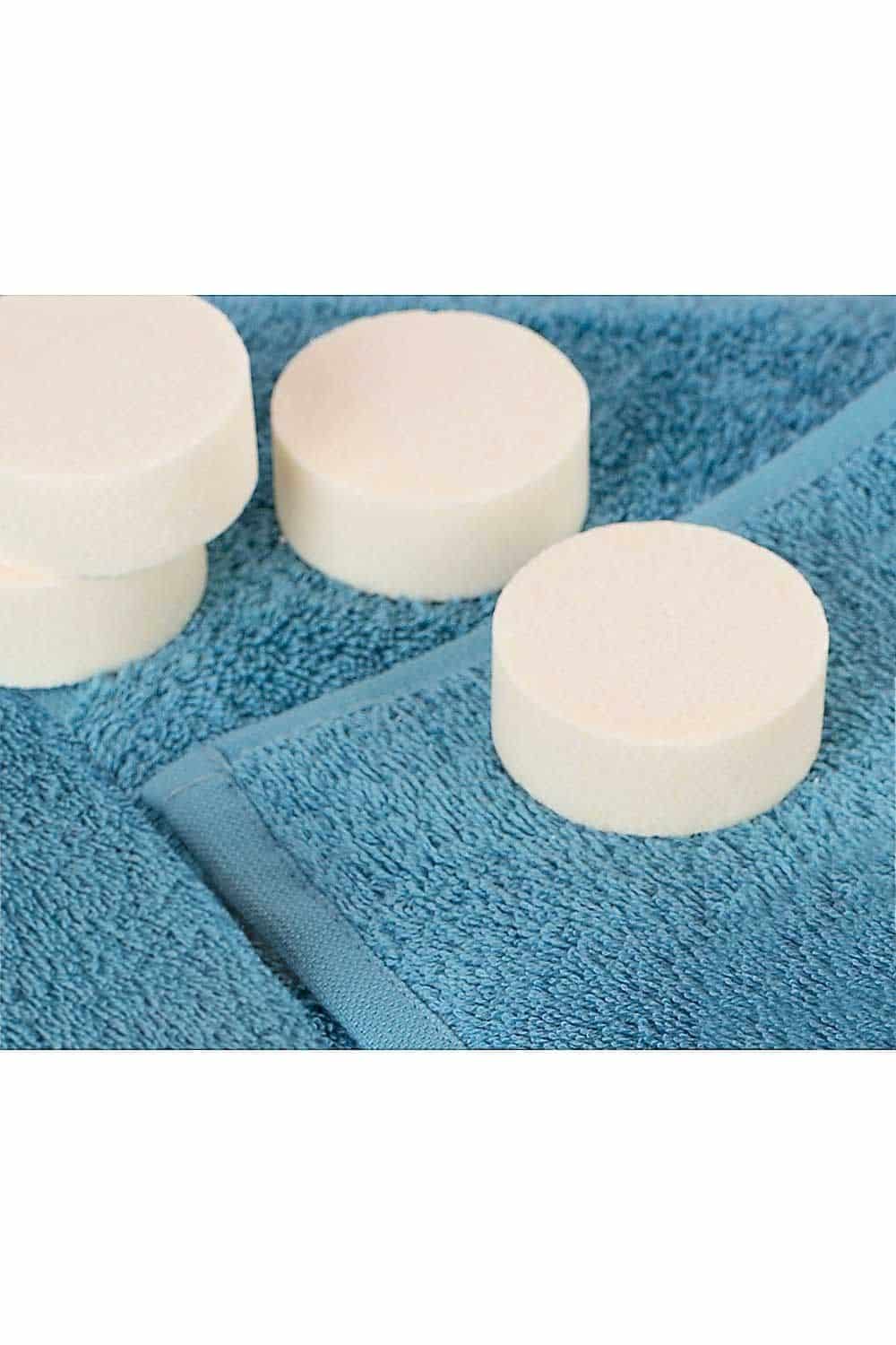 festes Shampoo ohne Duft liegt auf einem türkisen Handtuch