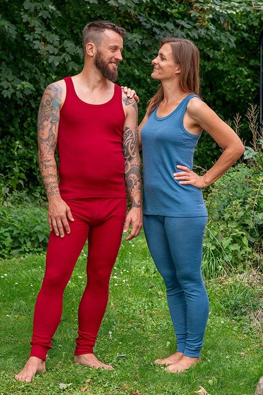 Mann und Frau stehen im Garten und tragen rotes und blaues Trägerhemd aus bio Wolle (kbT) mit langer Unterhose