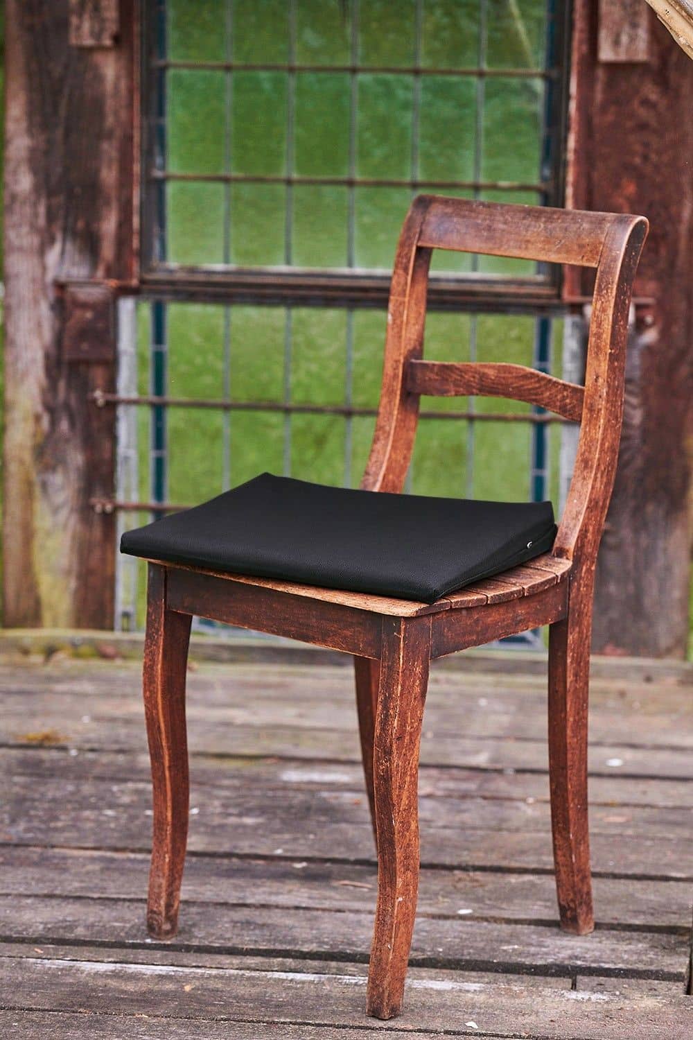 alter brauner Suhl auf dem Kissen mit dunkelgrauem Keilkissenbezug aus bio Baumwolle (kbA) vom Finkhof liegt