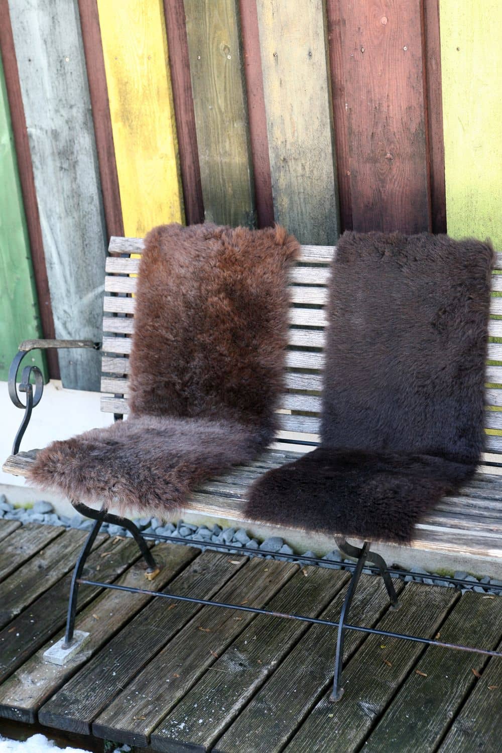 zwei braune Bankfellauflagen aus pflanzlich gegerbtem Finkhof Schaffell auf brauner Holzbank