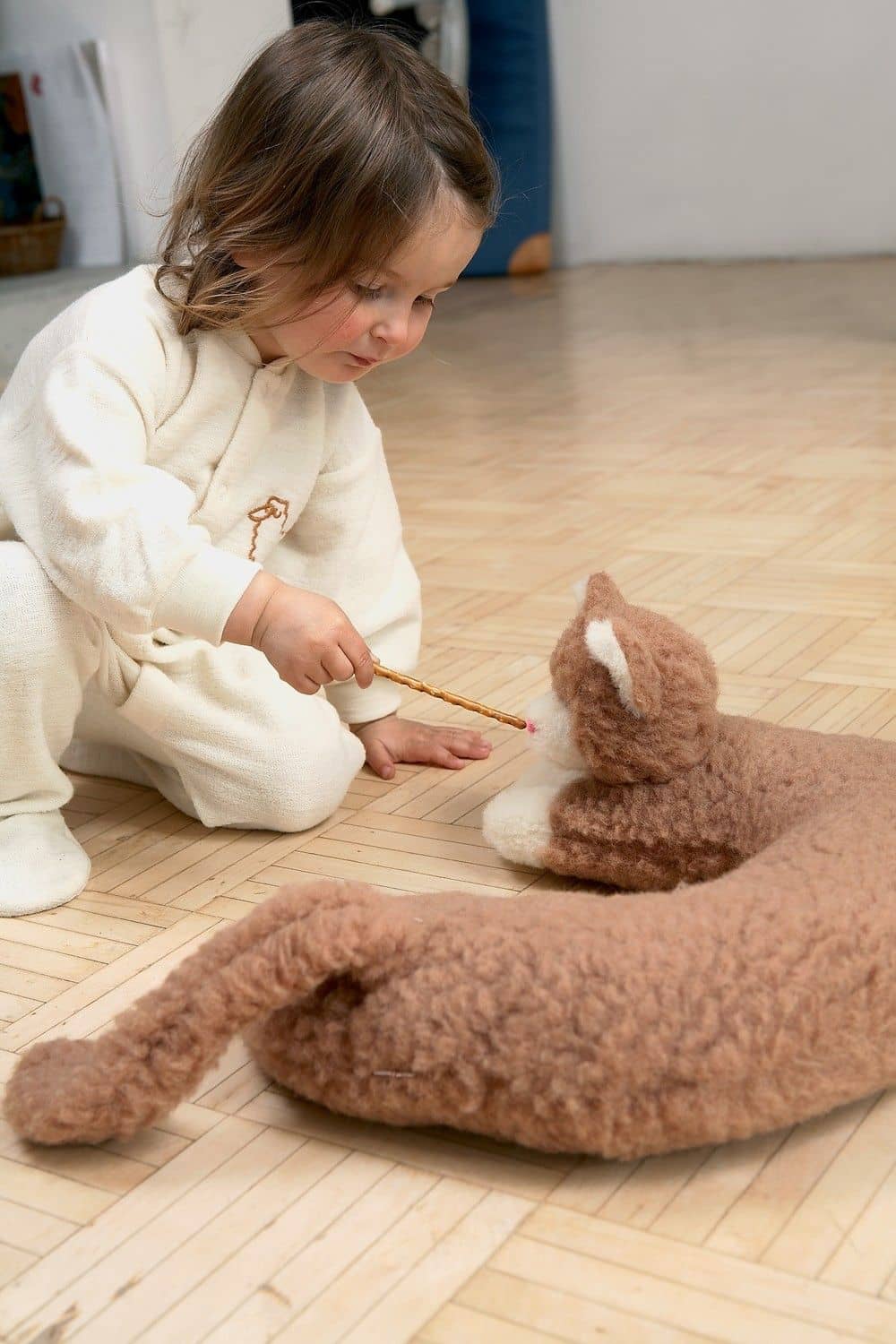 Wolltier Katze wird von Kind mit Salzstängeln gefüttert