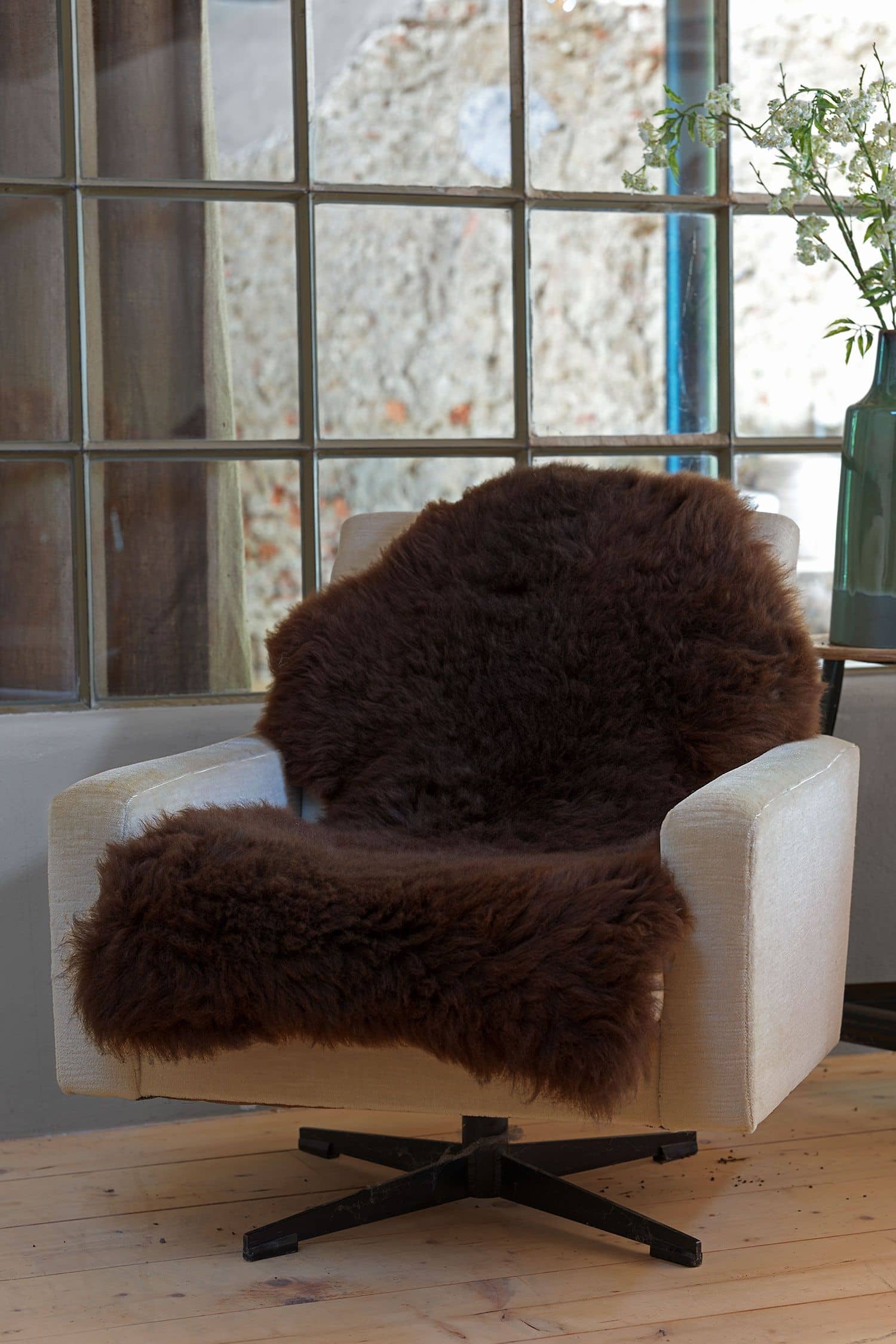 braunes pflanzlich gegerbtes Schaffell vom Finkhof auf einem beigen Sessel