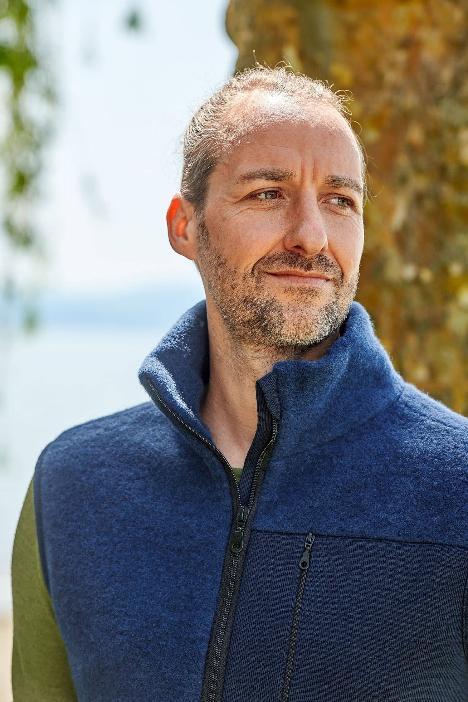 Portraitaufnahme von Mann mit marineblauer Wollfleece Weste aus bio Merinowolle (kbT) vom Finkhof