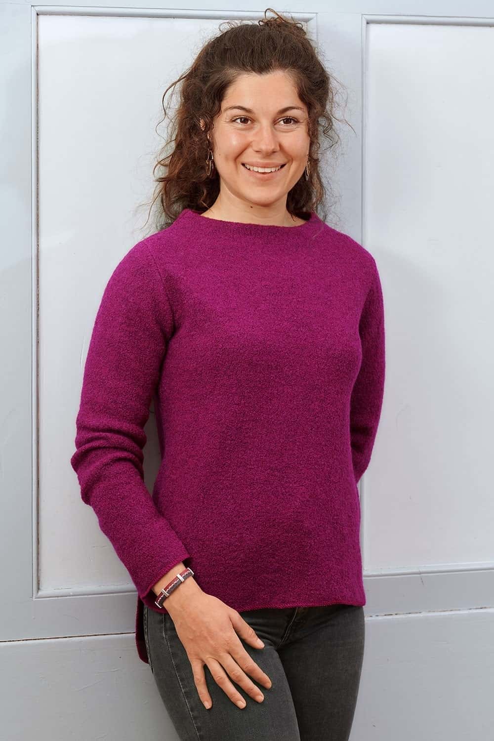 Model mit schwarzer Jeans und pinkem Wollshirt trägt beerefarbenes Lederarmband mit silbernen Details