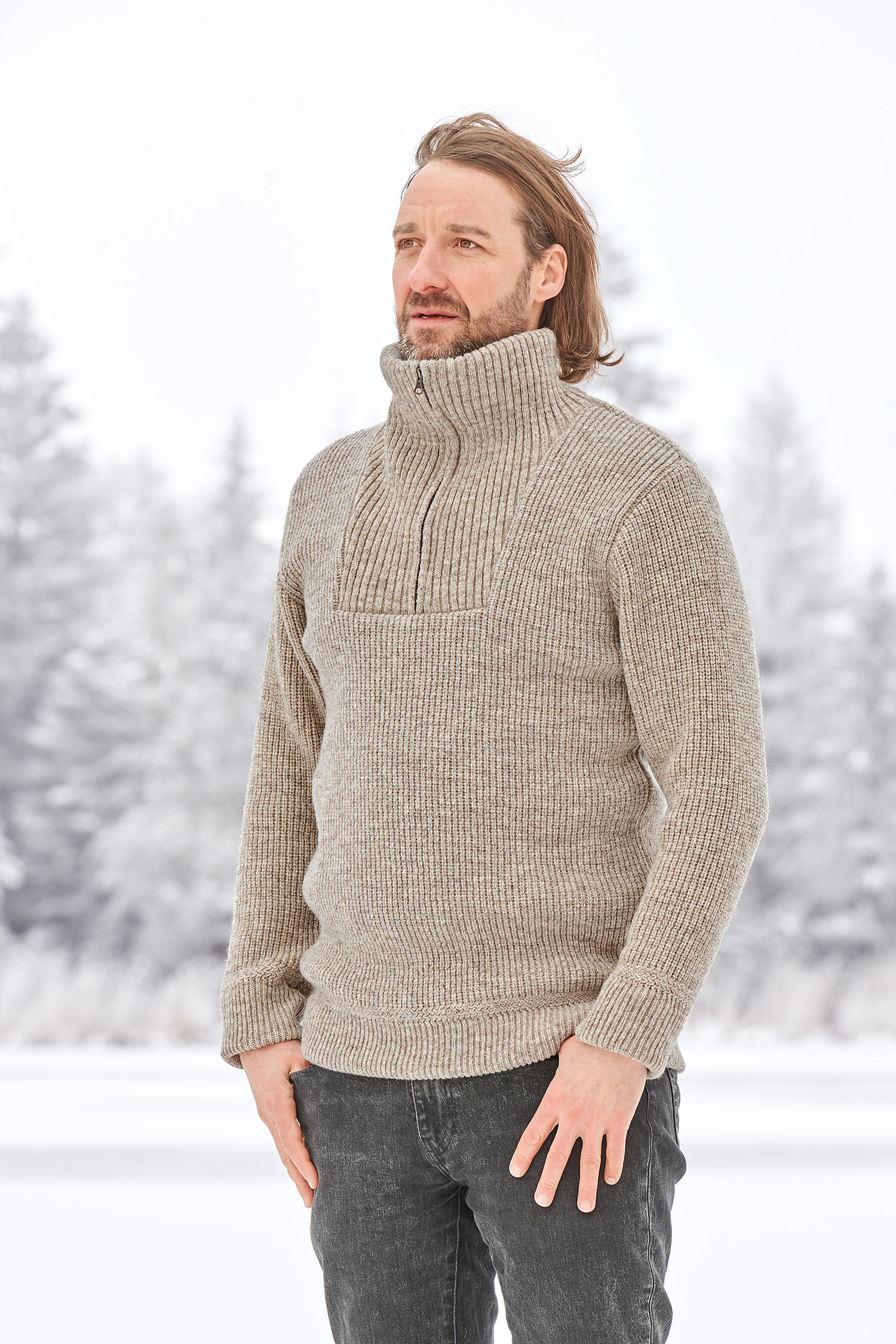 Mann in Schneelandschaft trägt einen grauen Finkhof Troyer aus bio Wolle (kbT)