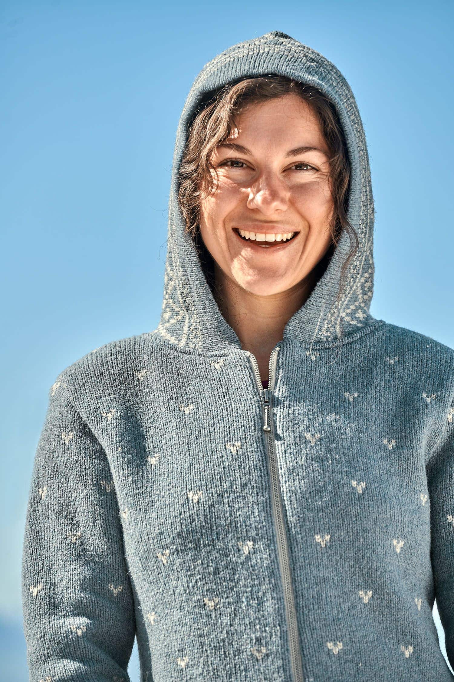 Frau hat die Kapuze der rauchblauen Norwegerkapuzenjacke aus bio Wolle (kbT) vom Finkhof auf