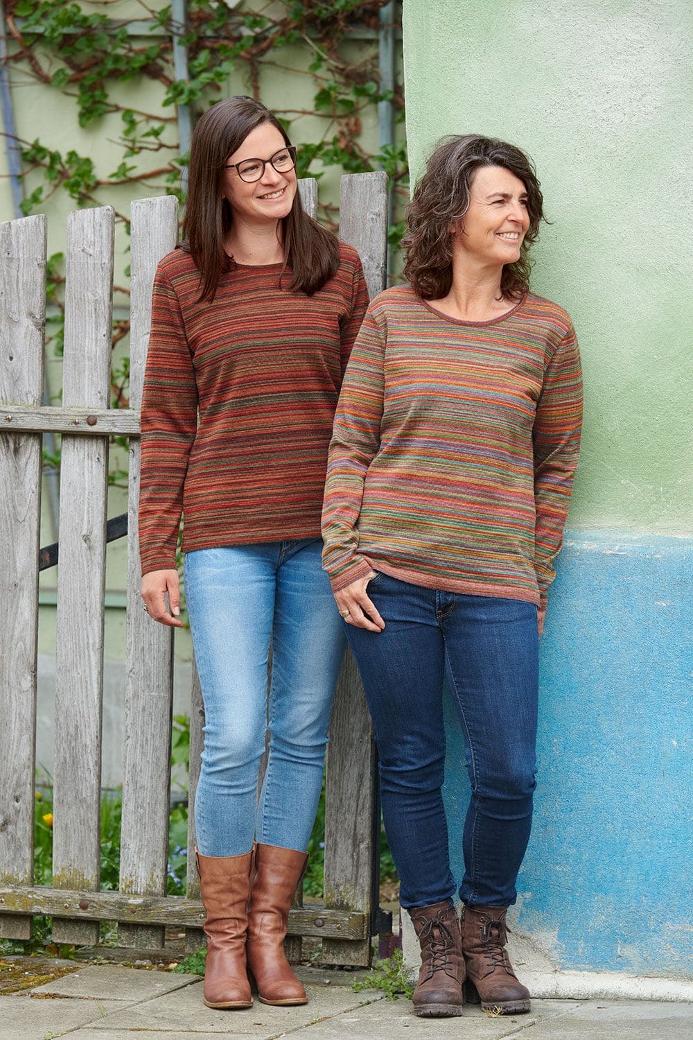 Wollshirt Feinringel Frauen an Wand gelehnt tragen buntes Wollshirt mit Ringelmuster vom Finkhof aus bio Wolle (kbT)