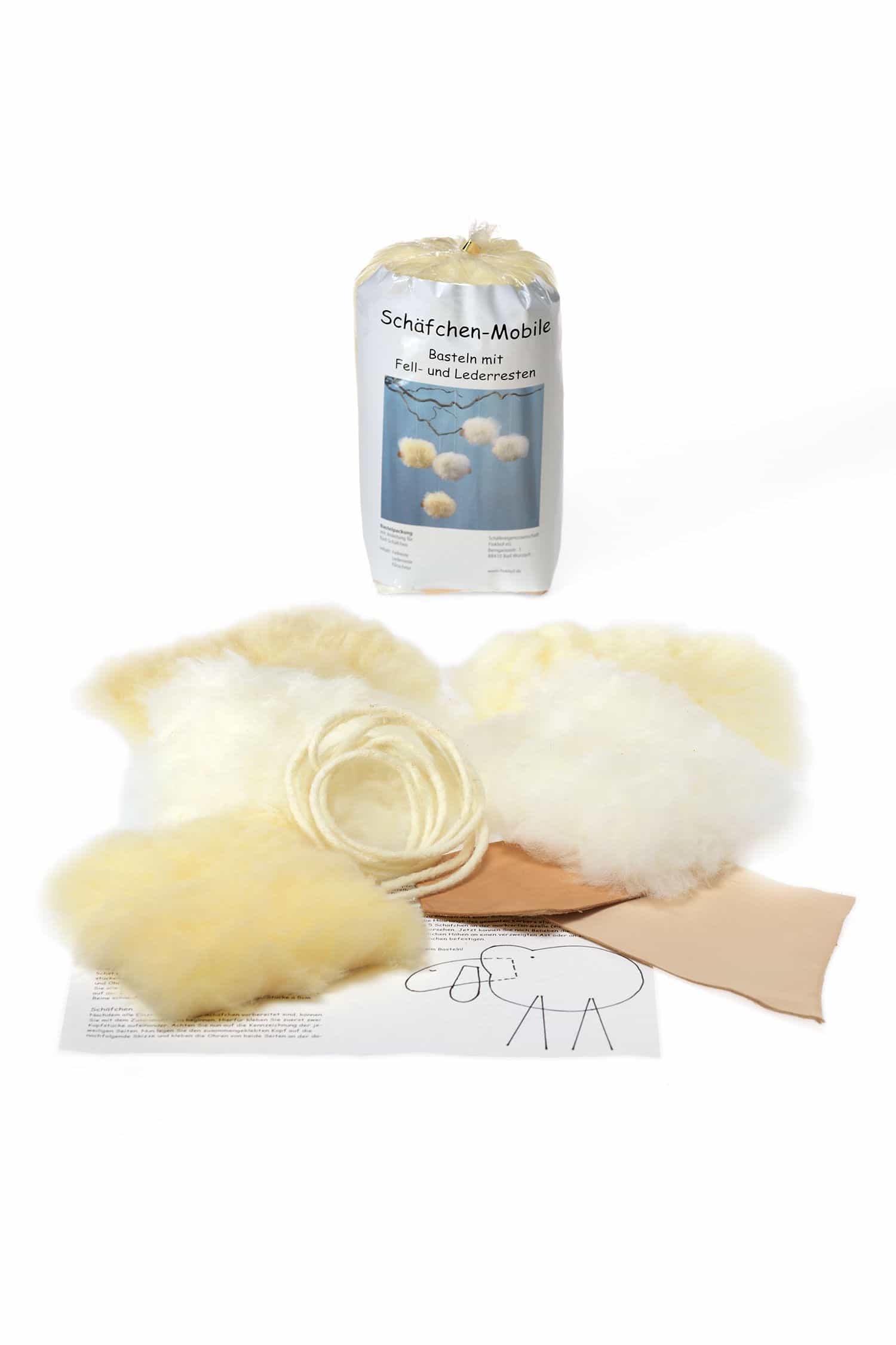 Bastelpackung Schäfchenmobile vom Finkhof mit Inhalt der Bastelpackung vor verschlossener Packung