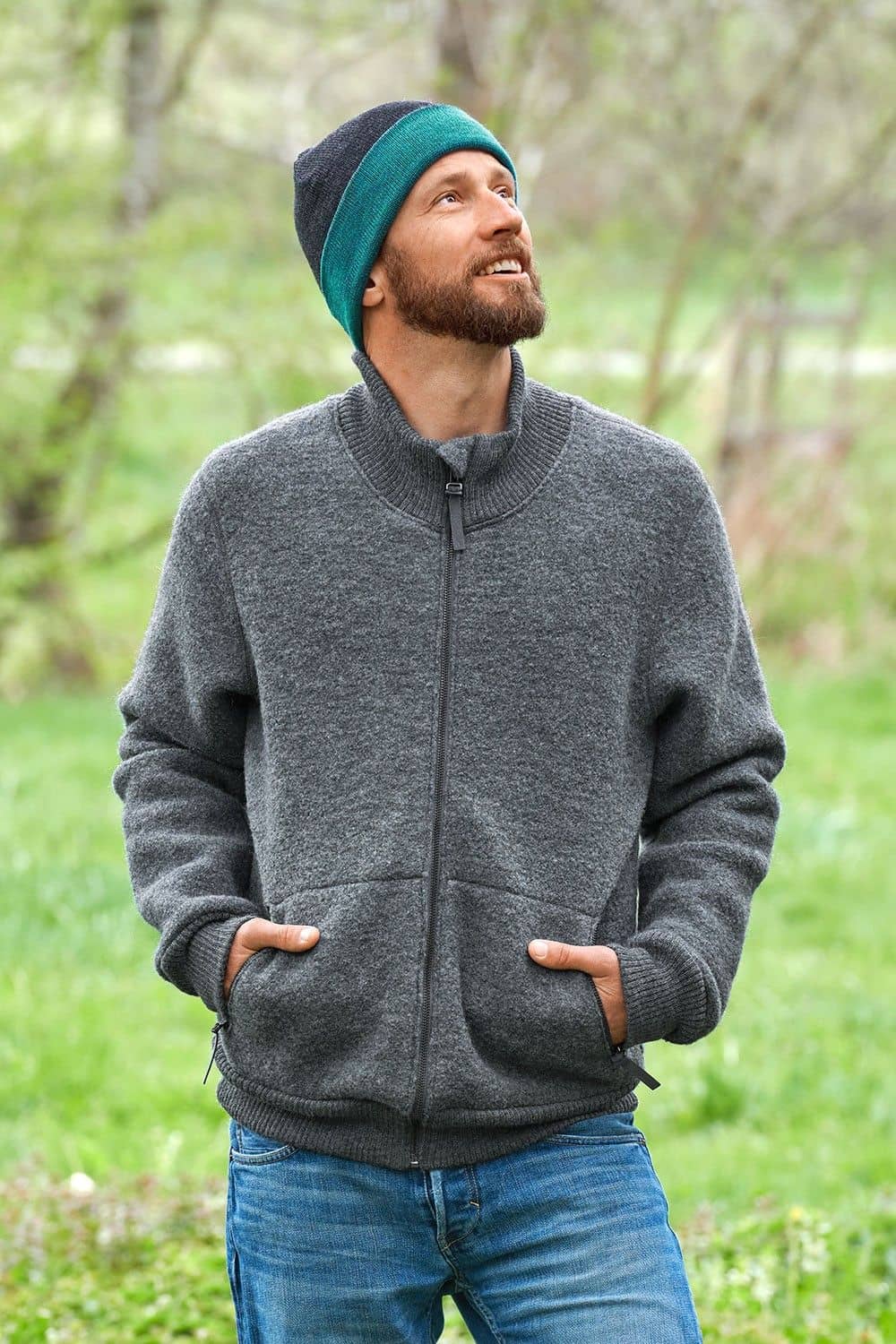 Mann mit grauer Jacke trägt eine türkise/anthrazitgraue Wendemütze aus bio Wolle (kbT) vom Finkhof