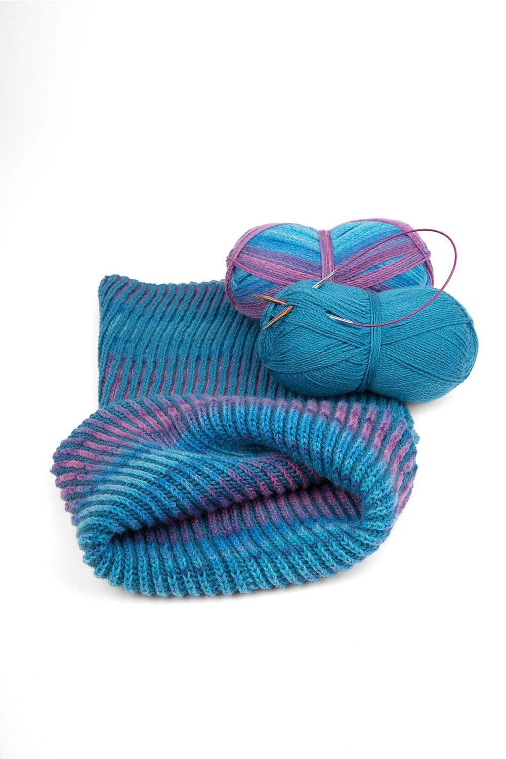 feine Finkhof Sockenwolle mit blau lila Farbverlauf aus bio Wolle (kbT) als Knäule und fertigem Loop im Vordergrund