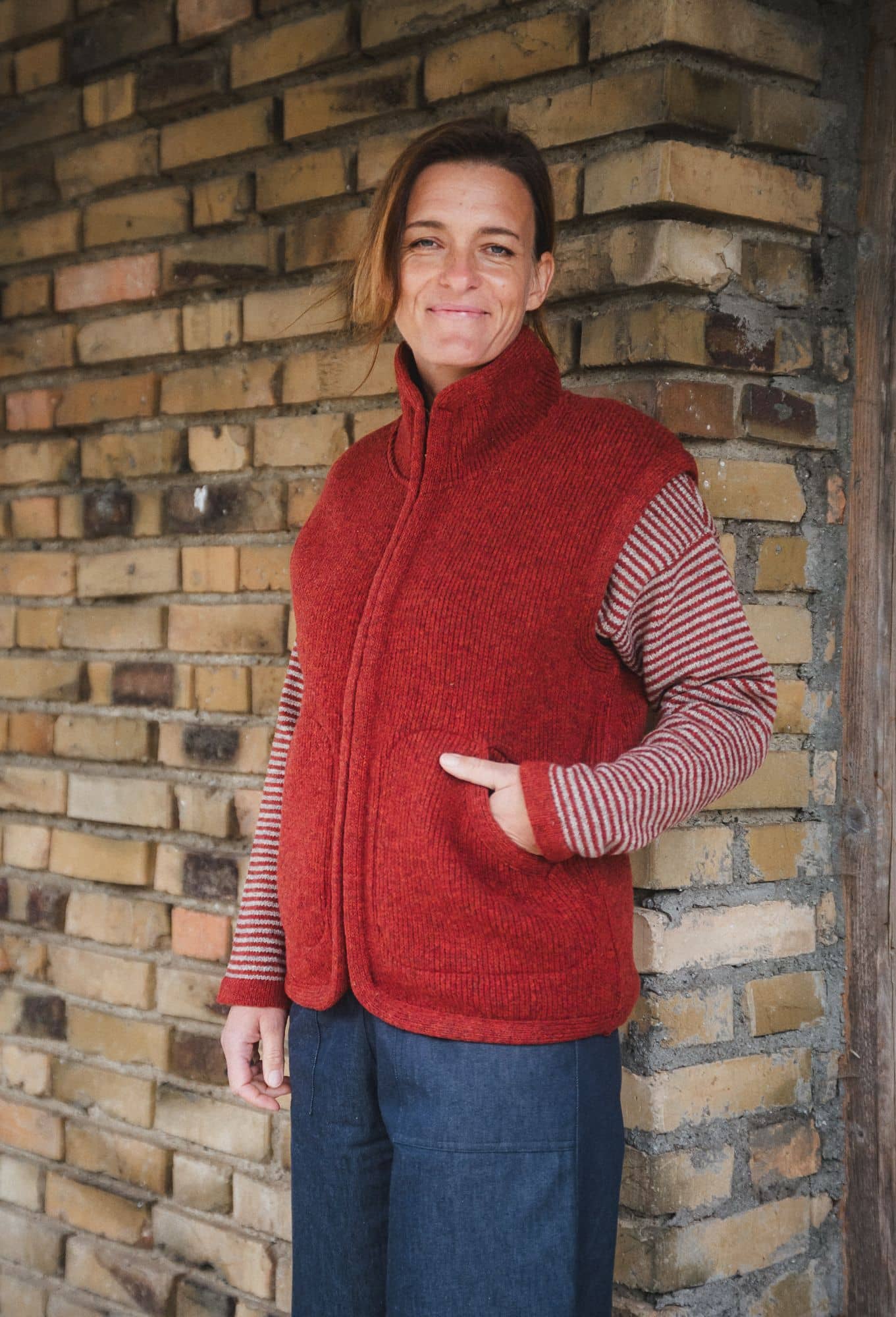 Frau mit rotem Streifenpulli trägt eine rote Wollwalkweste ohne Ärmel aus bio Wolle (kbT) vom Finkhof