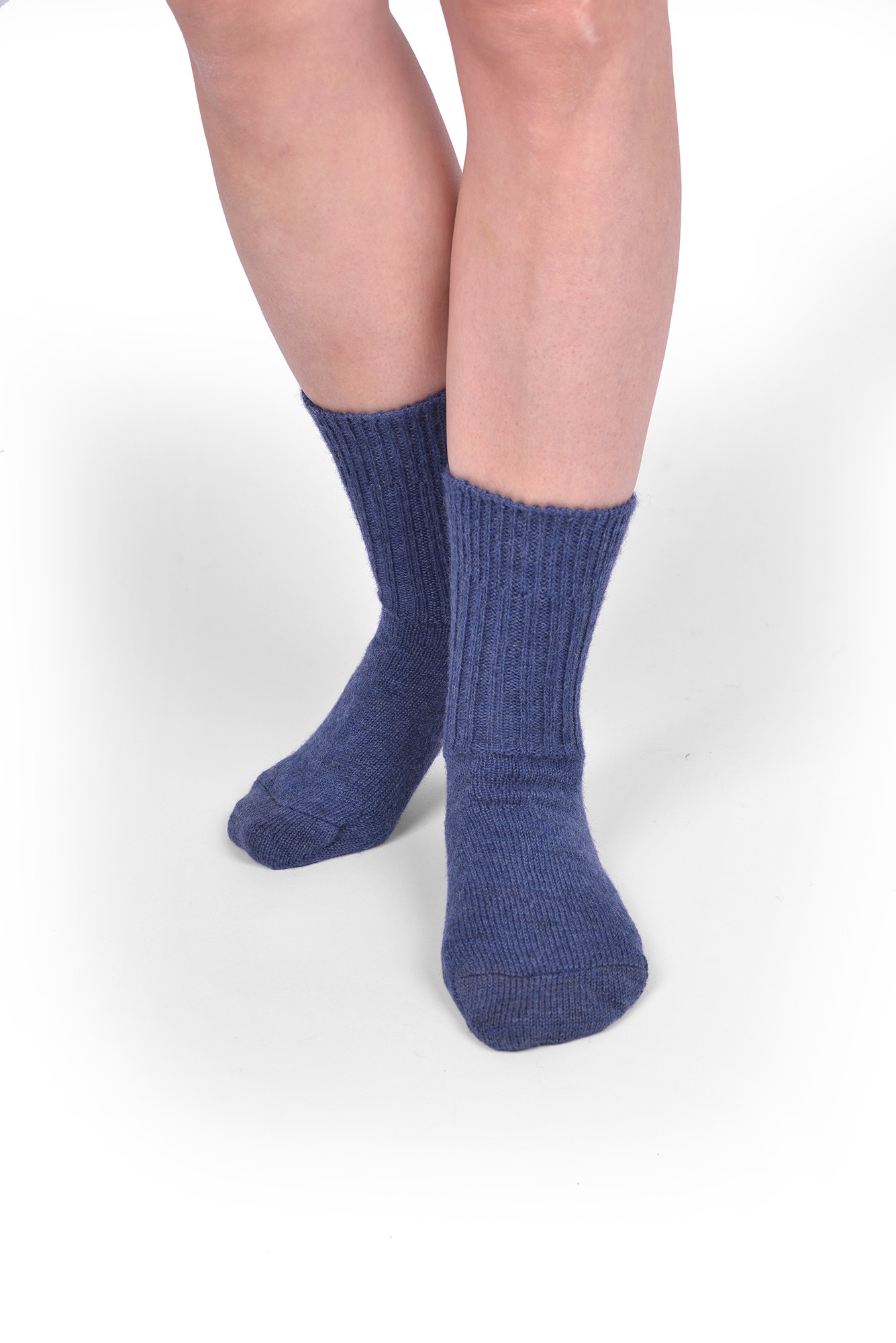 Mittlere Wollsocken aus reiner Bio-Schurwolle Person trägt jeansblaue Wollsocken aus bio Wolle (kbT) in mittlerer Dicke, von vorne