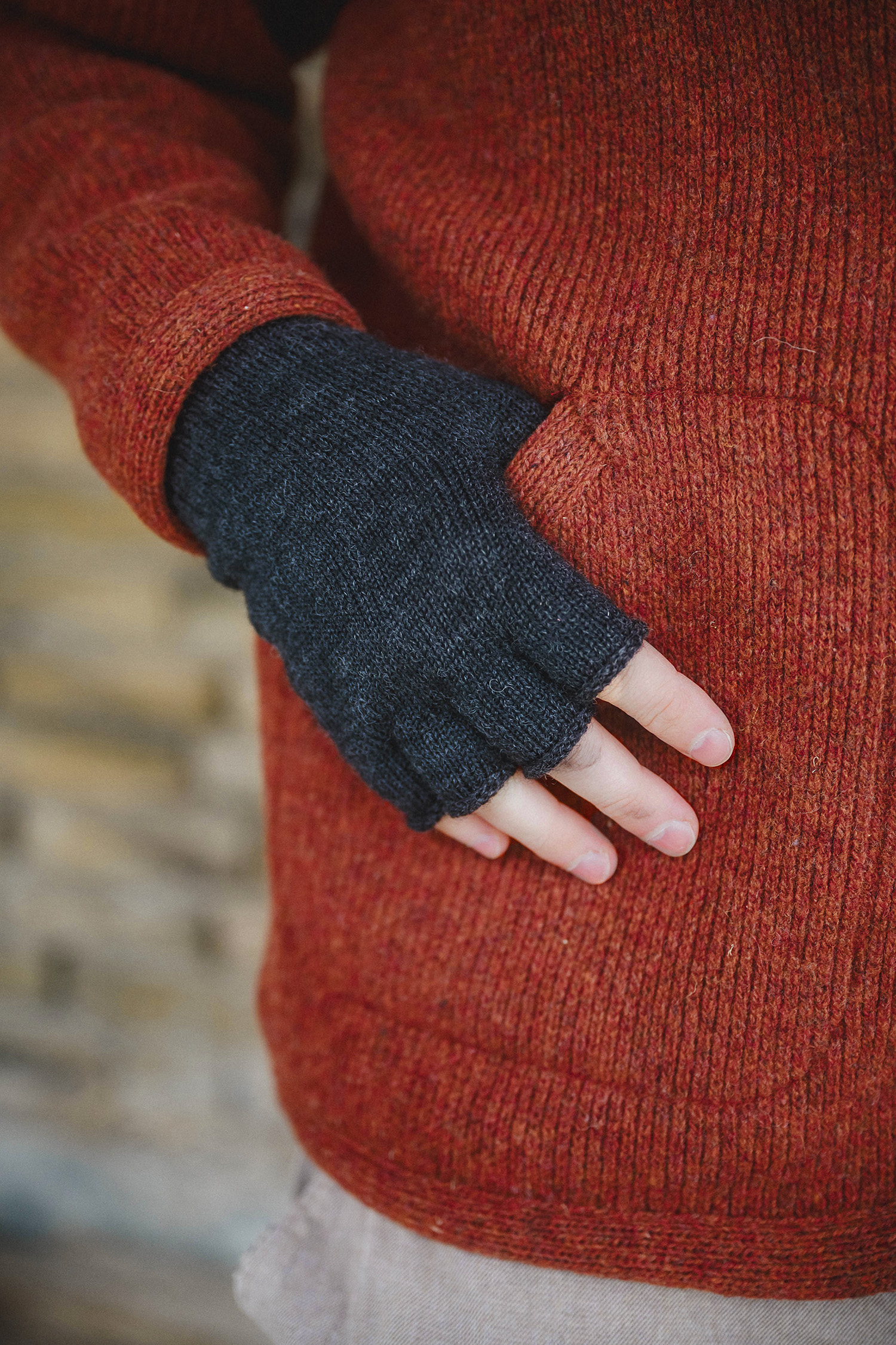Strickhandschuhe ohne Finger aus reiner Bio-Schurwolle Mann und Frau mit Troyer und Mütze tragen anthrazitgraue Strickhandschuhe ohne Finger aus bio Wolle (kbT) vom Finkhof