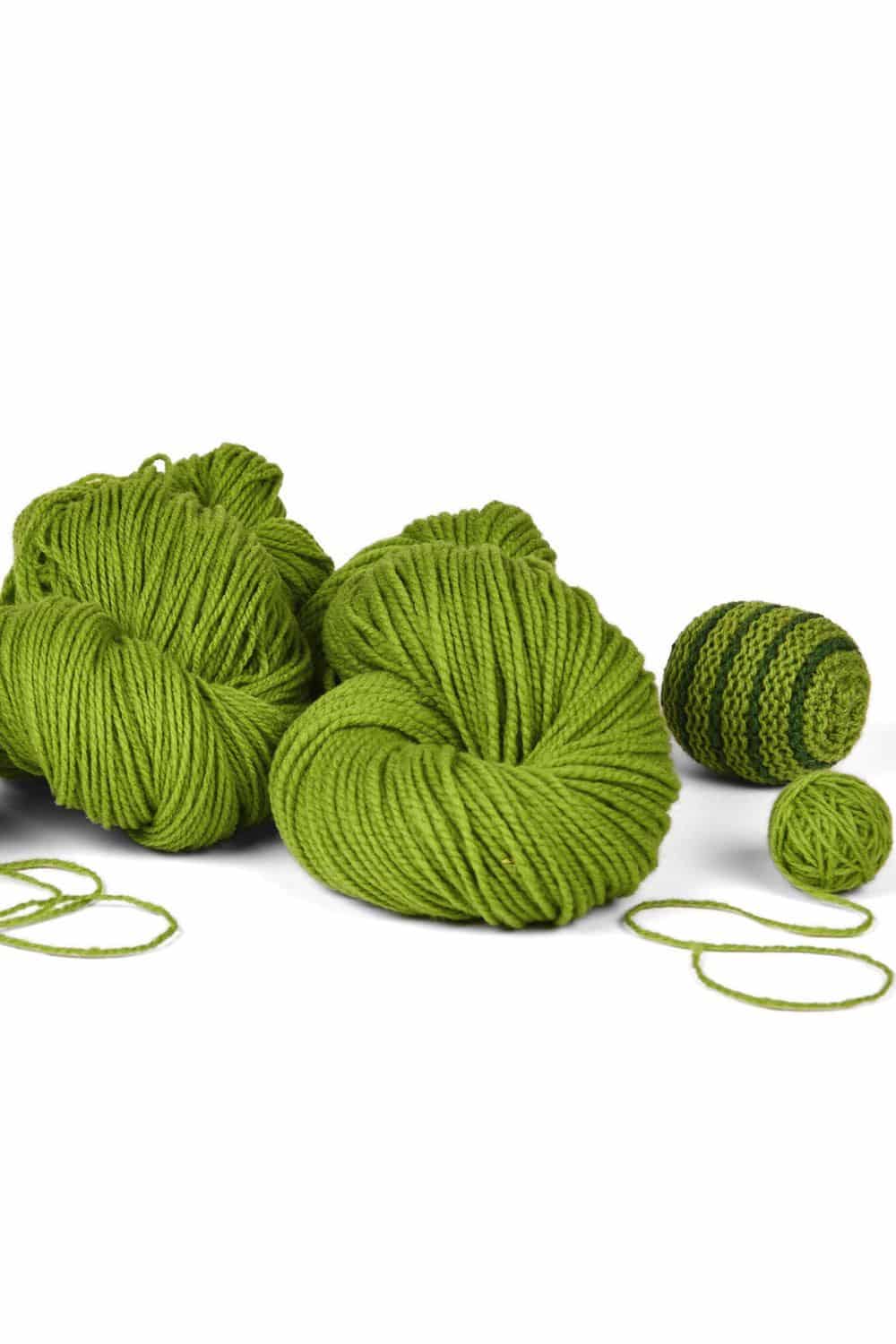 dünne hellgrüne Finkhof Merinowolle aus bio Wolle (kbT) mit Strickkugel daneben, weißer Untergrund