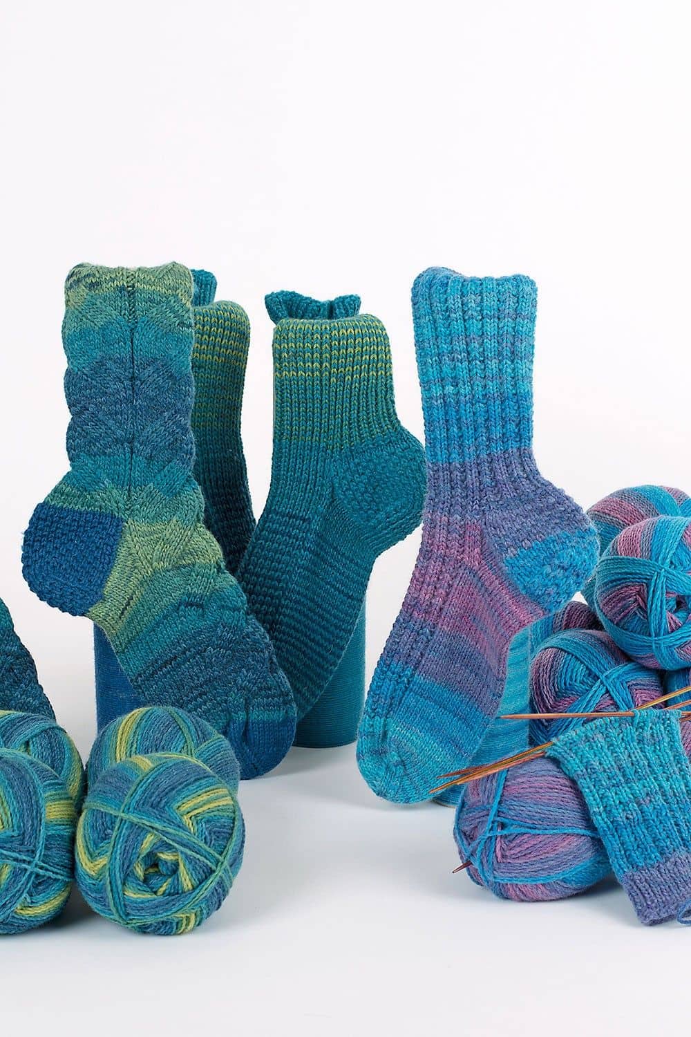 feine Finkhof Sockenwolle aus bio Wolle (kbT) mit Farbverlauf auf Bild mit Knäulen und fertigen Socken