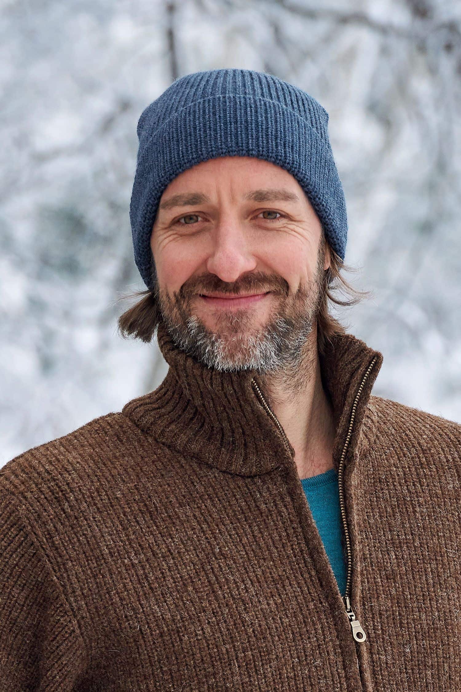 Wollmütze jeans Mann mit brauner Weste trägt eine jeansblaue Wollmütze aus bio Wolle (kbT) vom Finkhof