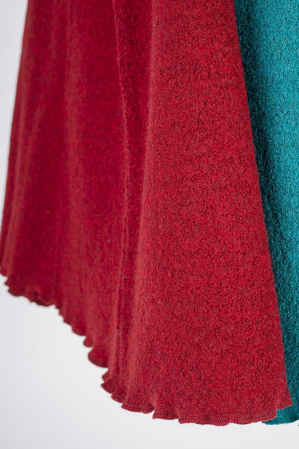 Nahaufnahme vom Abschluss eines roten und türkisen Rocks aus bio Wolle (kbT)
