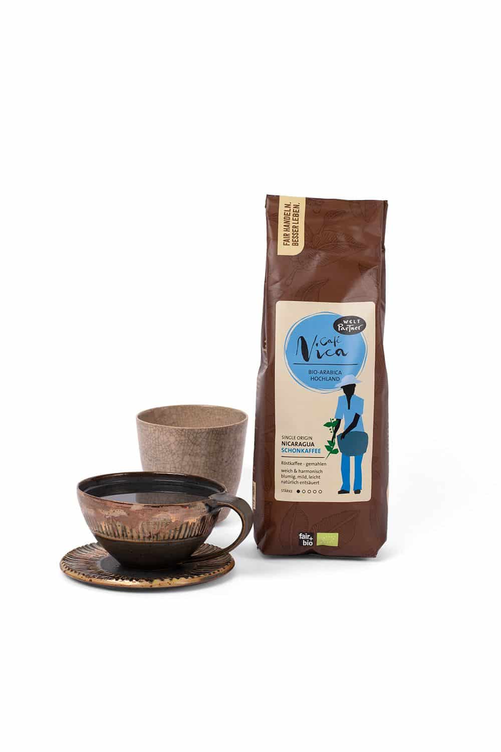 Cafe Nica Schonkaffee 500 g Cafe Nica Schonkaffee in brauner 500g Packung neben Tasse und Becher