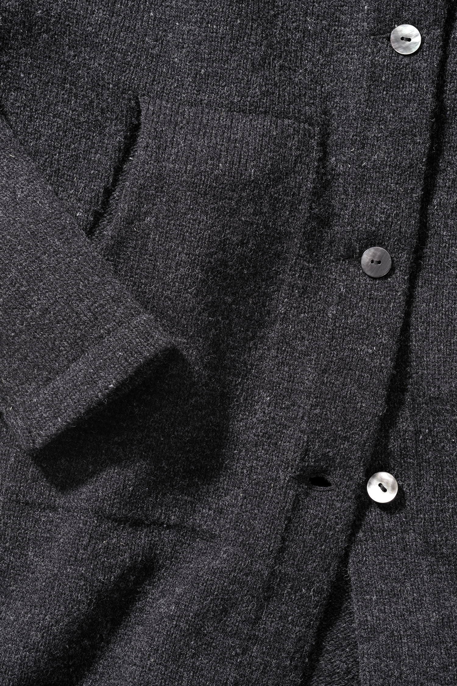 Detailaufnahme der Taschen und Knöpfe des dunkelgrauen Finkhof Strickmantel aus bio Wolle (kbT)