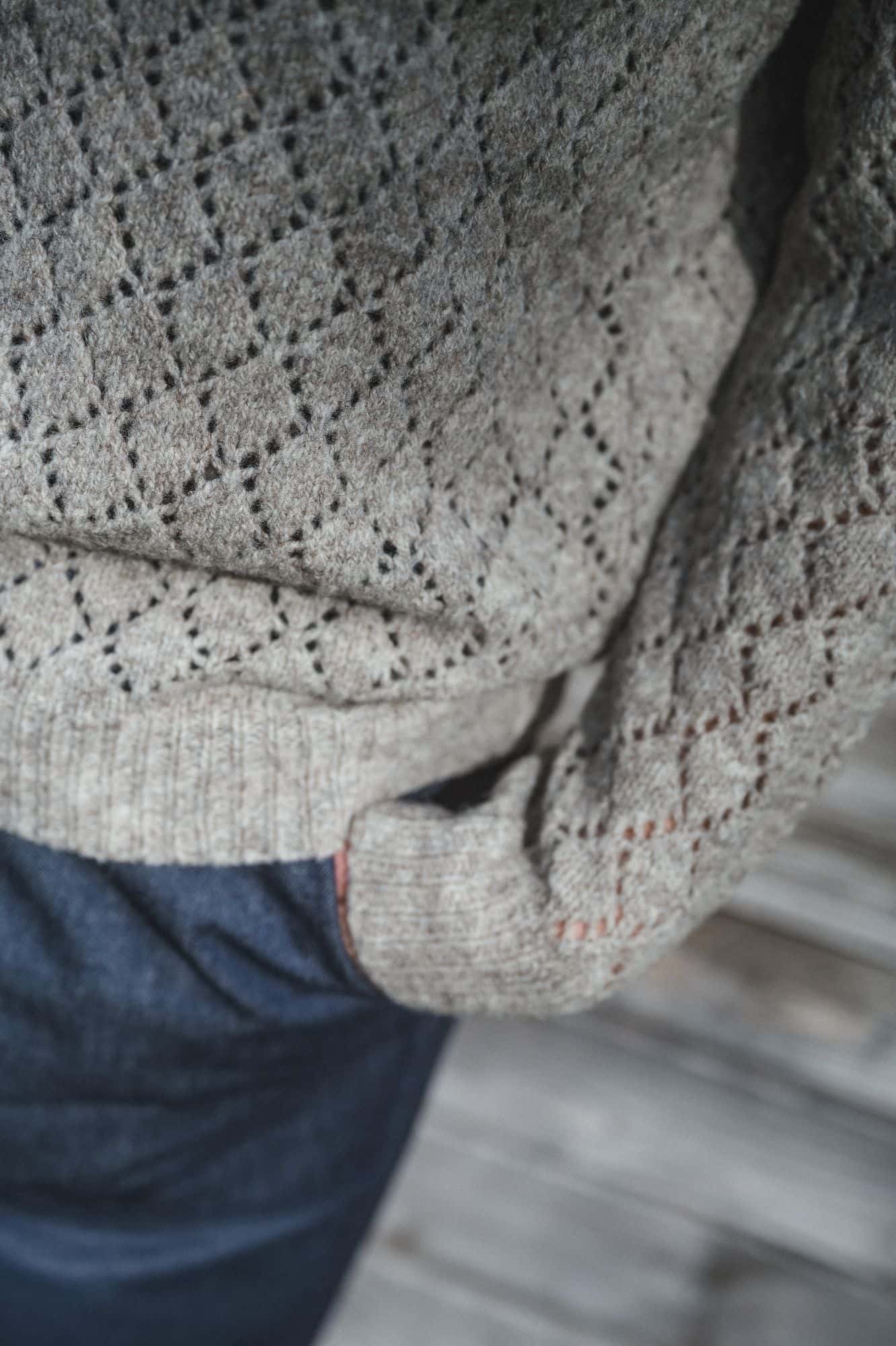 Nahaufnahme der Bündchen des grauen ungefärbten Strickpullunder mit Ajourmuster aus Bio-Wolle vom Finkhof
