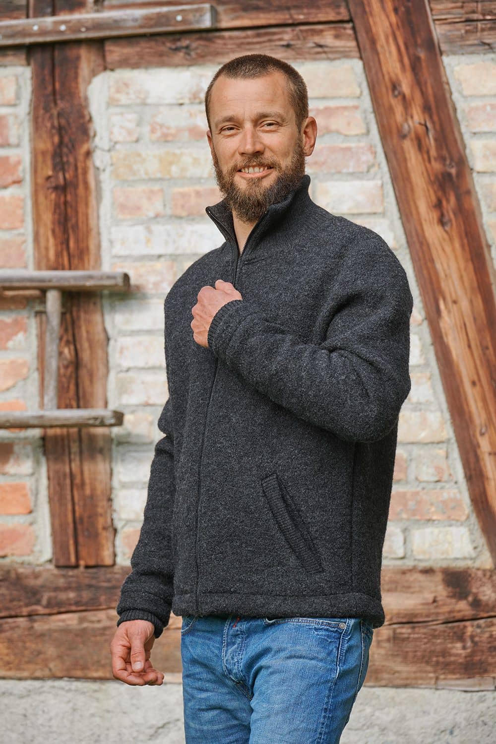Mann leicht von Seite mit anthrazitfarbener Leichtwalkjacke vom Finkhof aus bio Wolle (kbT)