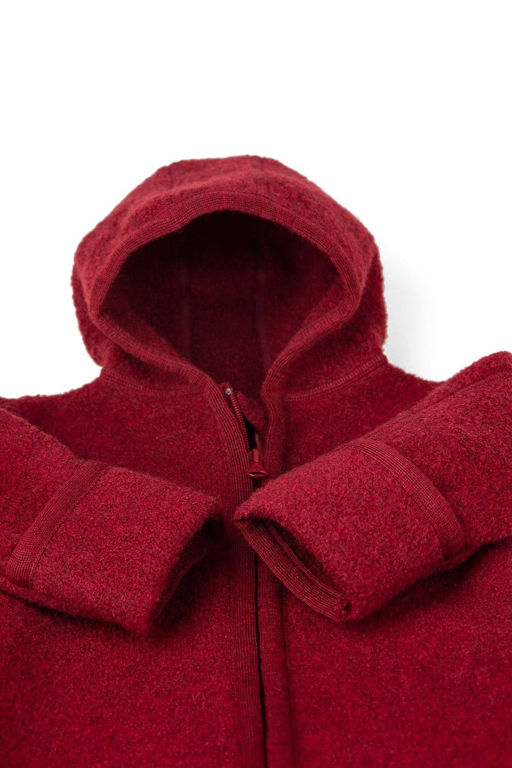 Detailaufnahme der Ärmel und der Kapuze des roten Finkhof Walkoverall aus bio Wolle (kbT)