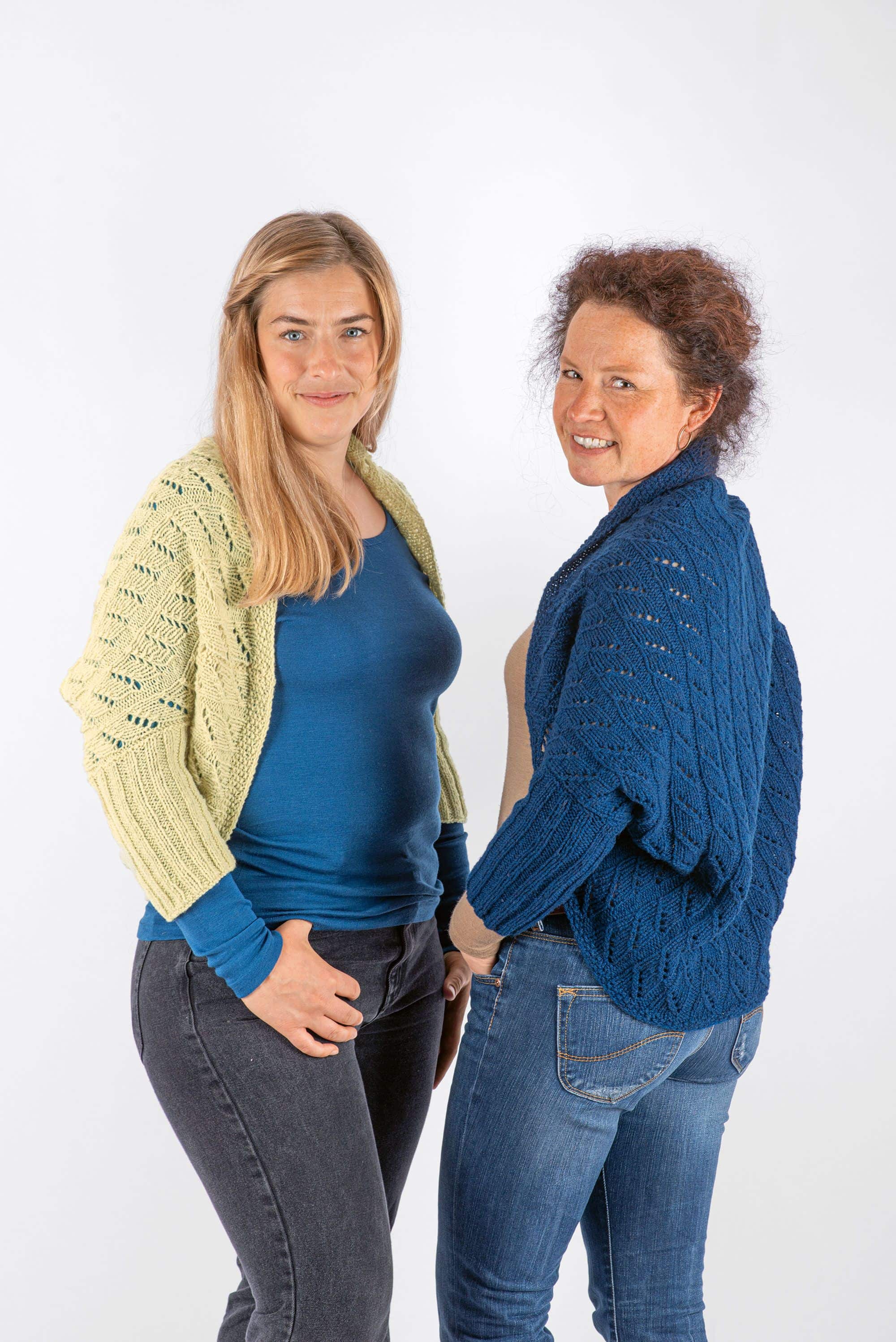 Frauen mit unifarbenen Shirts haben sich blauen und grünen Seelenwärmer um Schultern gelegt