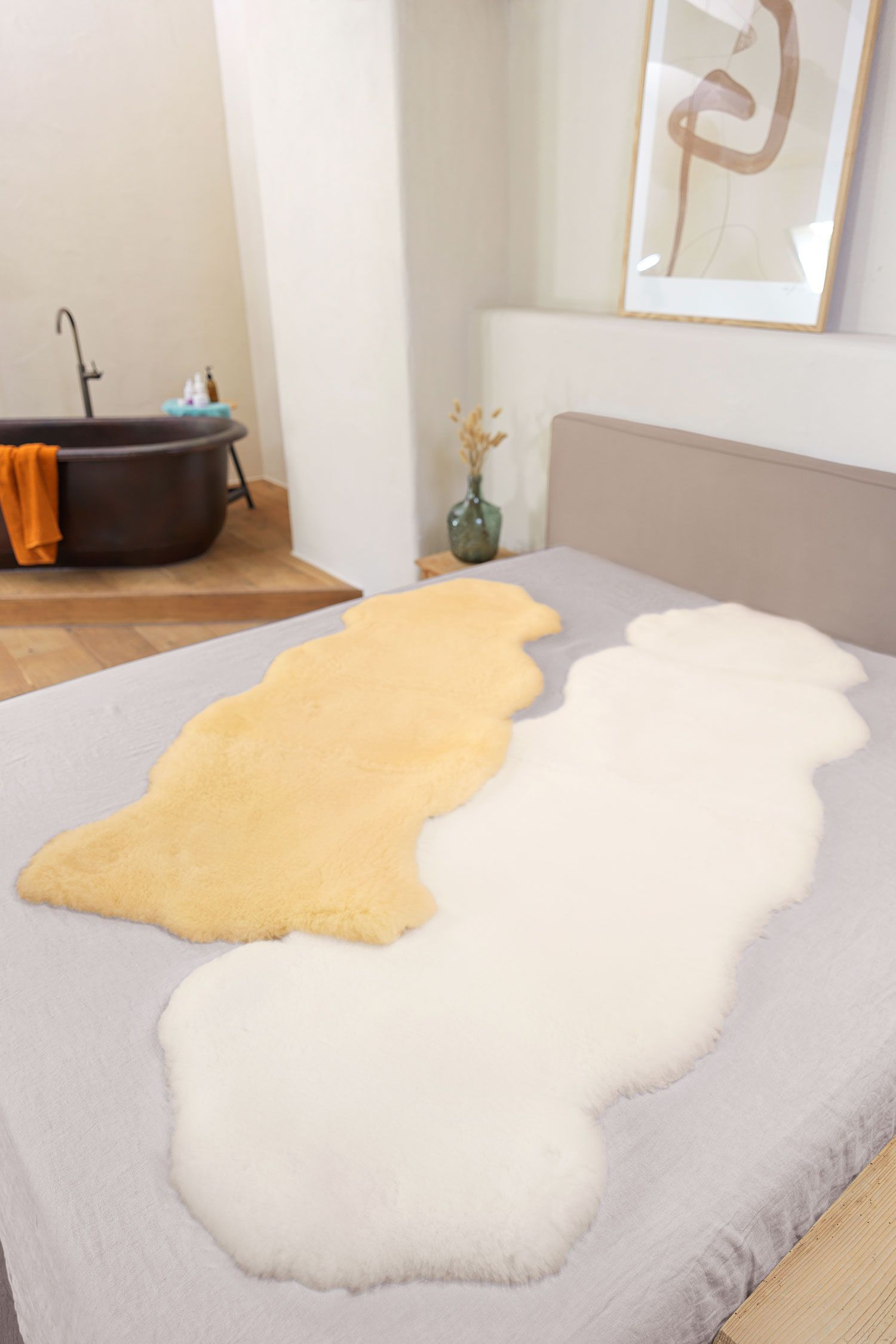 Felldecke natürliche Fellform Felldecken in natürlicher Form aus Schaffell vom Finkhof auf grauem Bett