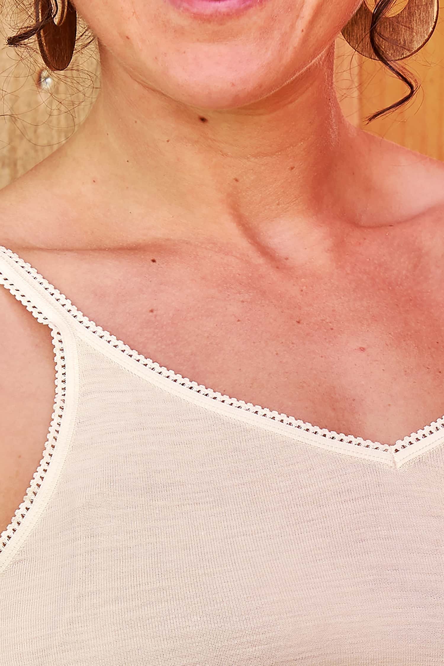Detailaufnahme der Spitze des naturweißen Unterhemds aus Bio-Wolle und Seide für Damen mit V-Ausschnitt