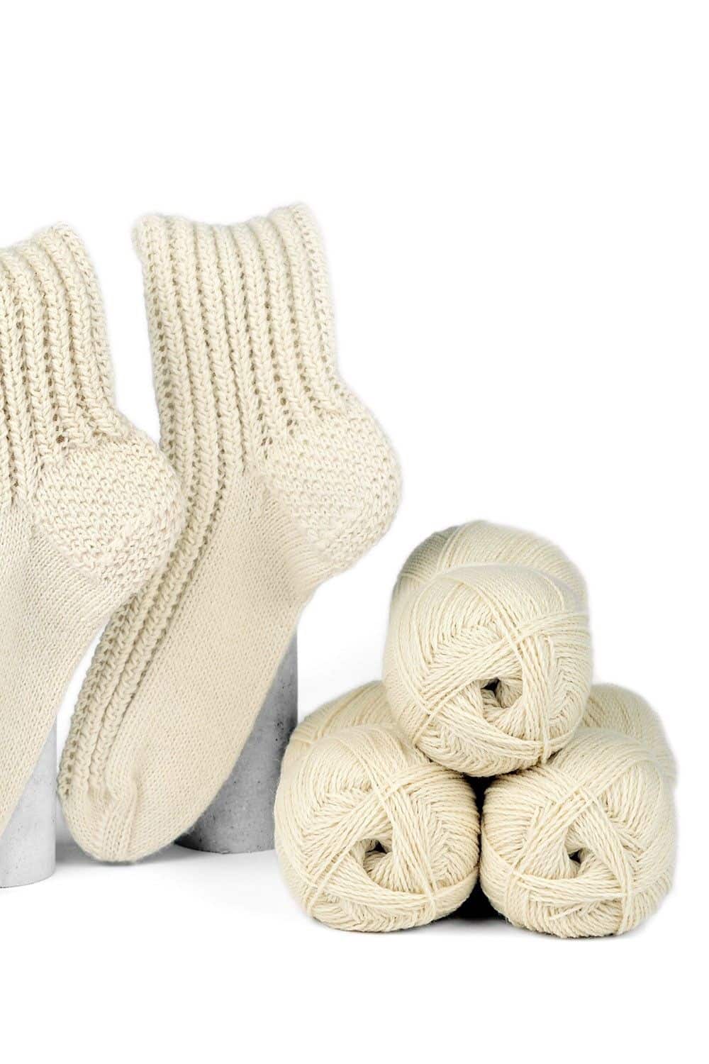 feine Finkhof Sockenwolle in naturweiß aus bio Wolle (kbT) mit Wollknäul und fertiger Socke