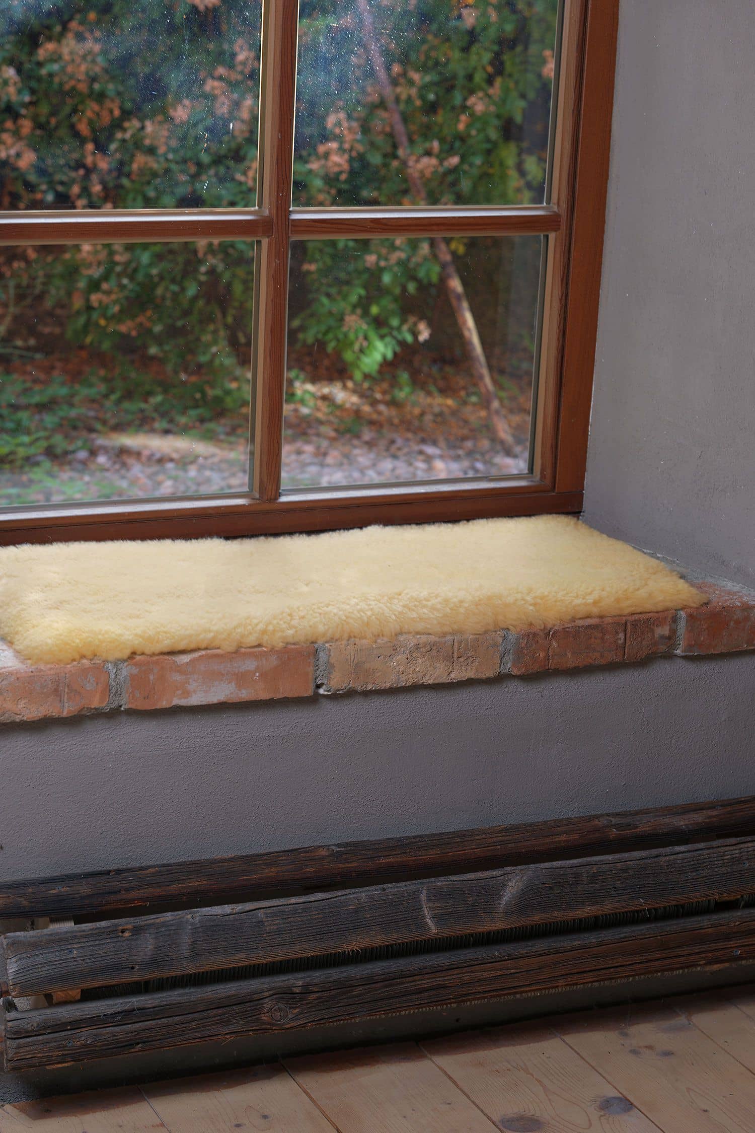 gelbliche relugan gegerbte Fellbankauflage vom Finkhof liegt auf gemauerter Fensterbank